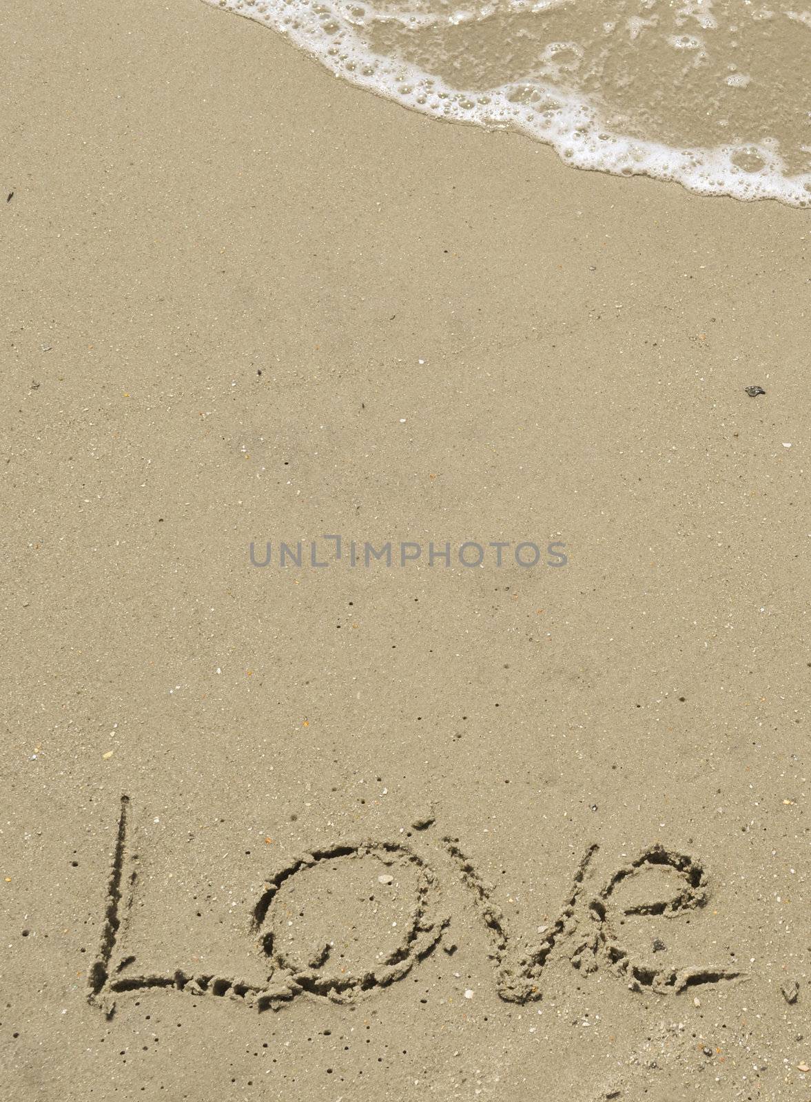 Love written in the sand with wave by RefocusPhoto