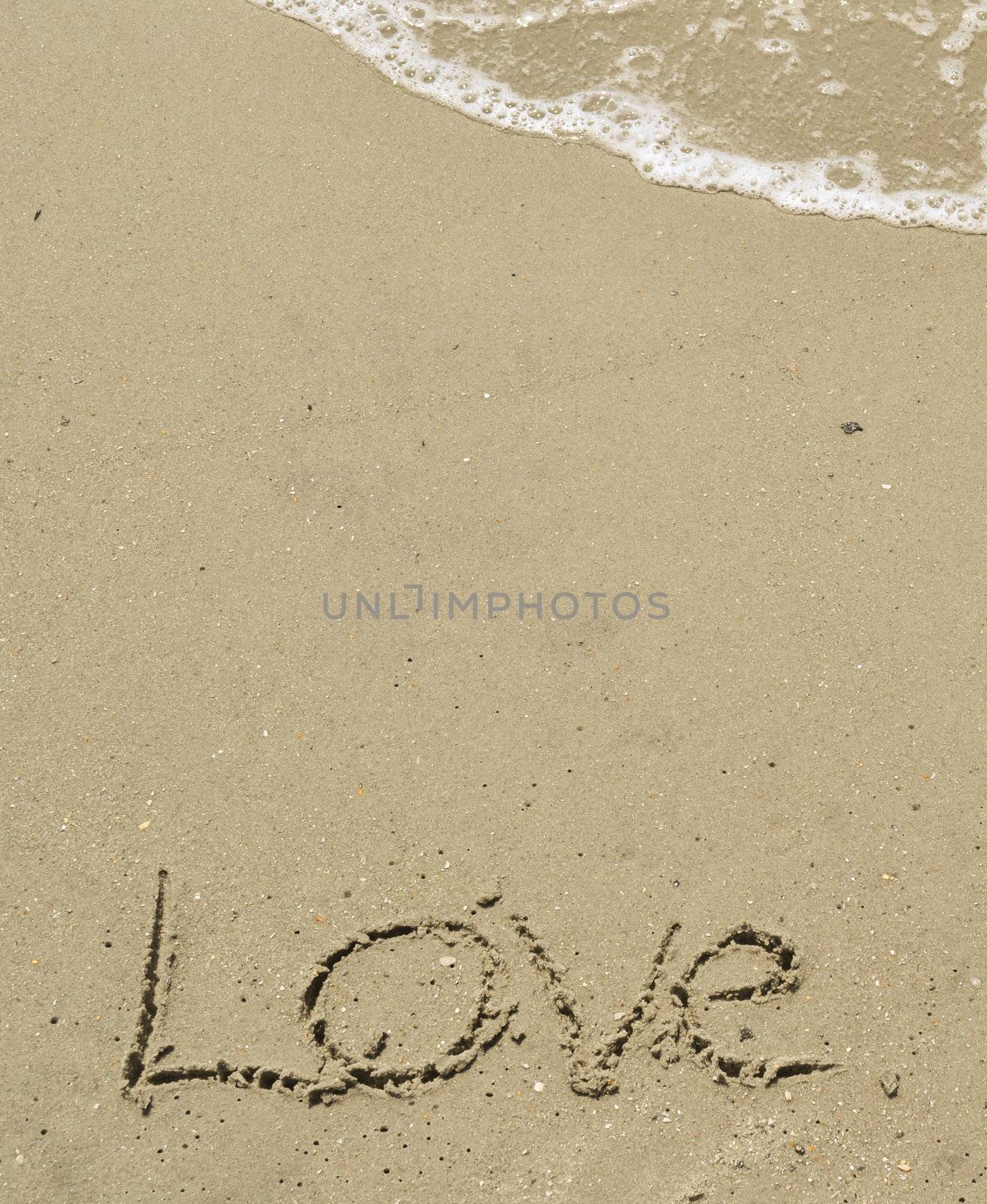 Love written in the sand with wave by RefocusPhoto