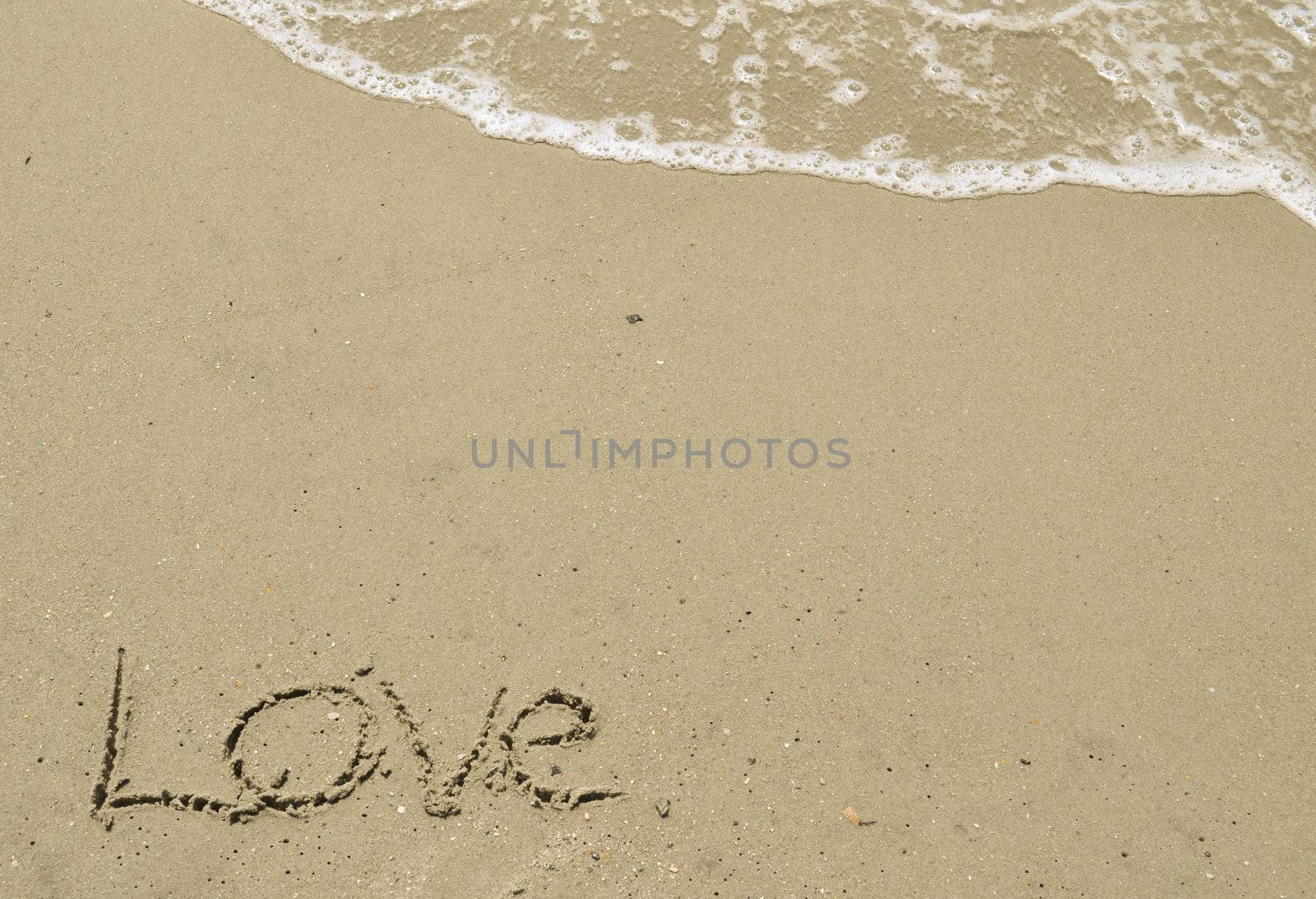 Love written in the sand with wave by RefocusPhoto