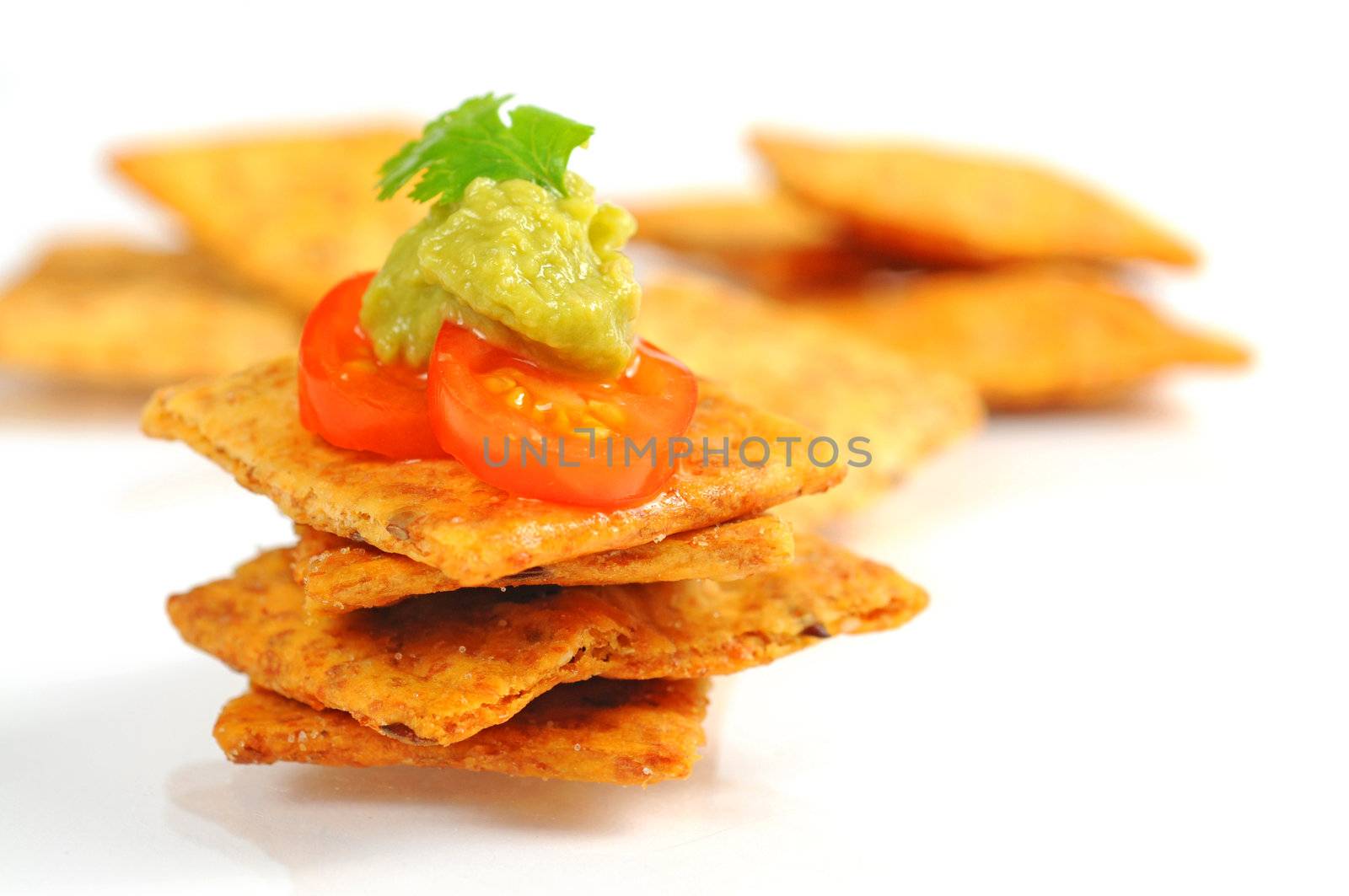 Delicious crackers topped with guacamole and tomato.