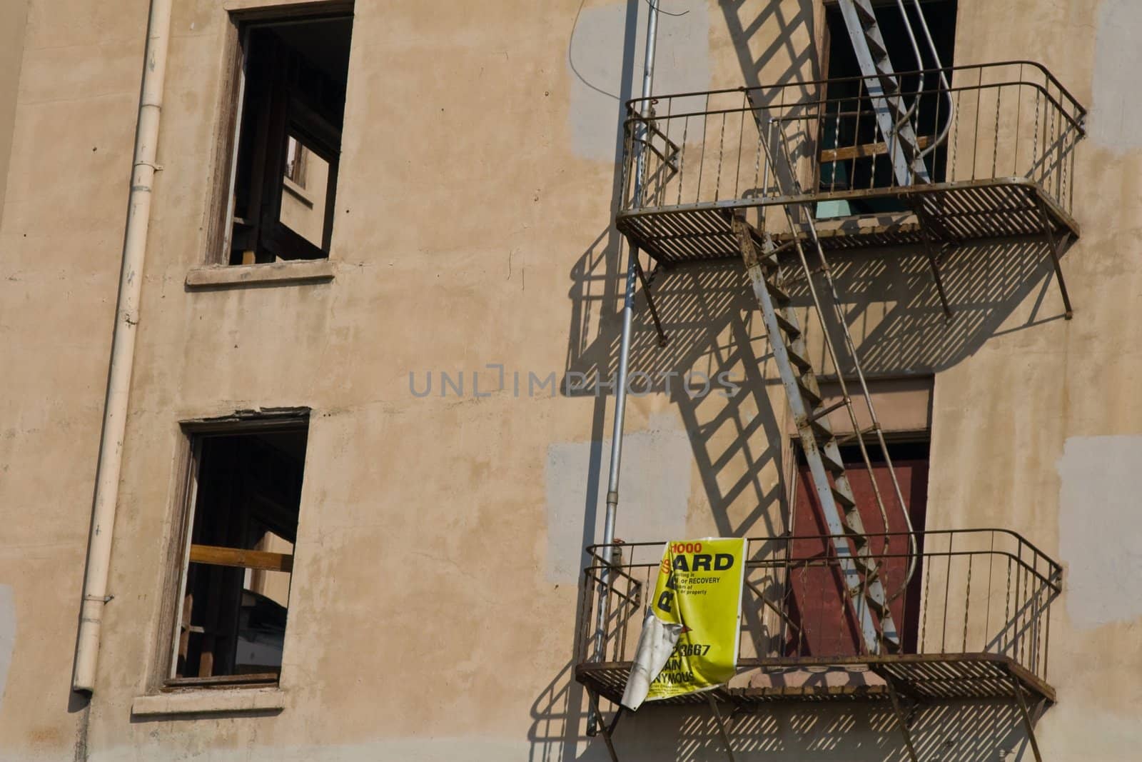 Detail of old hotel with focus on broken windows and rusty metal fire escapes