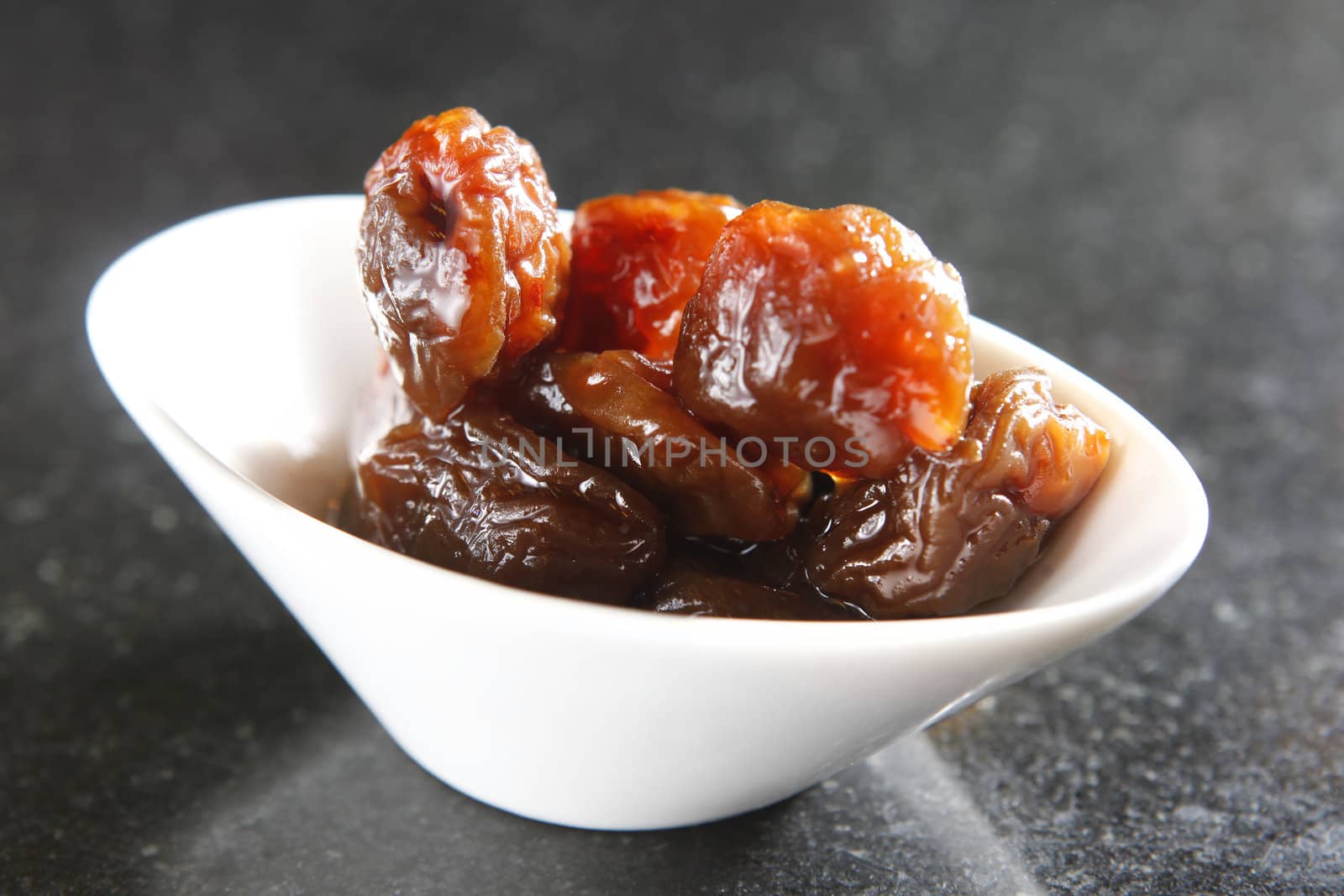 Preserved fruit, plum on the dish.