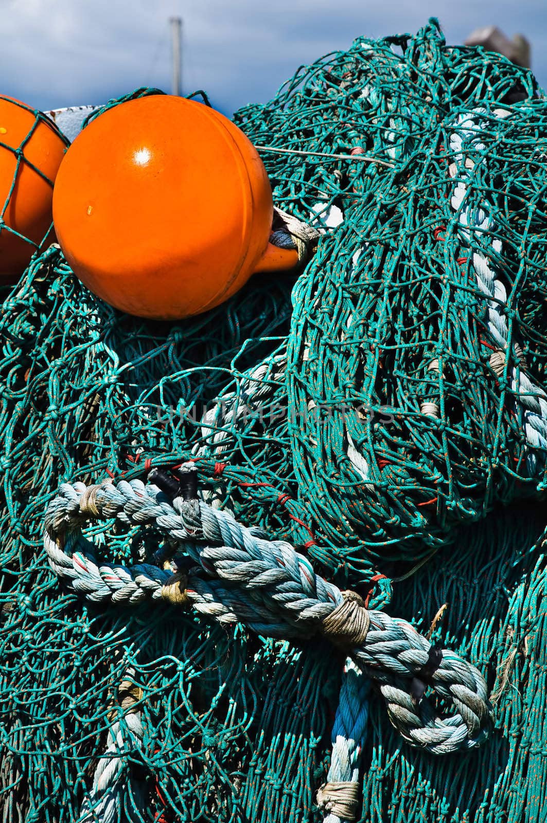 Close-up fishing net with a bright orange floats. by lobzik