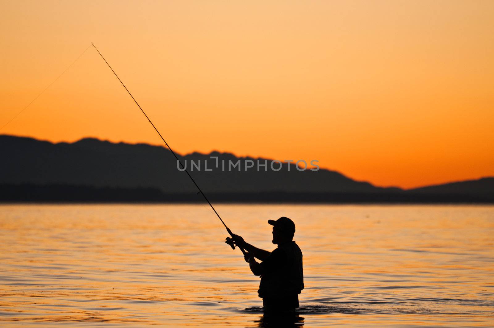Silhouette of a fisherman at sunset. 