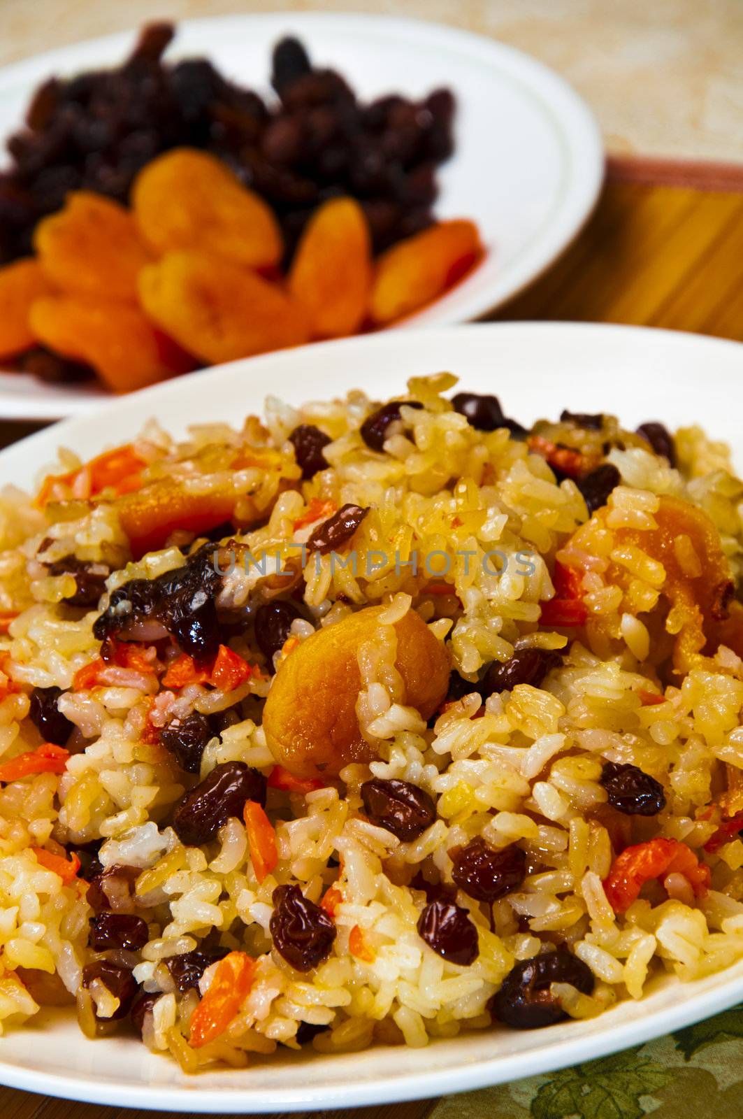 Pilaf made ​​of rice, fresh carrots and dried plums, grapes, apricots.