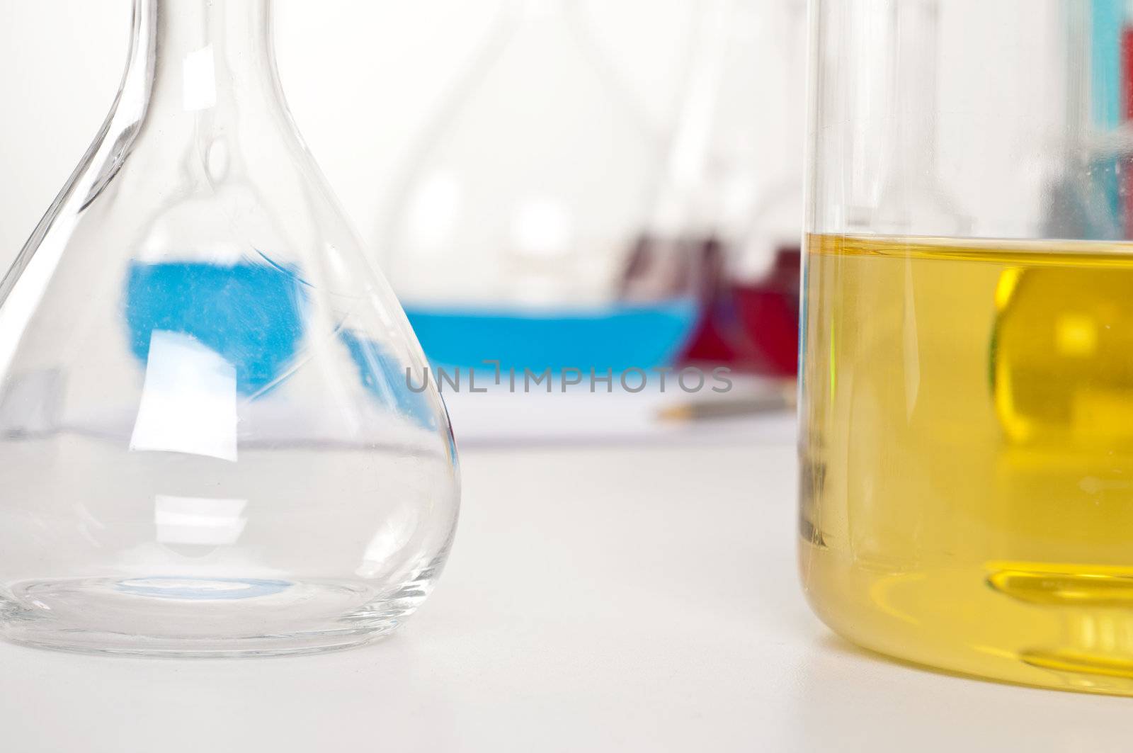 flask with yellow liquid, in the background microscope and other items