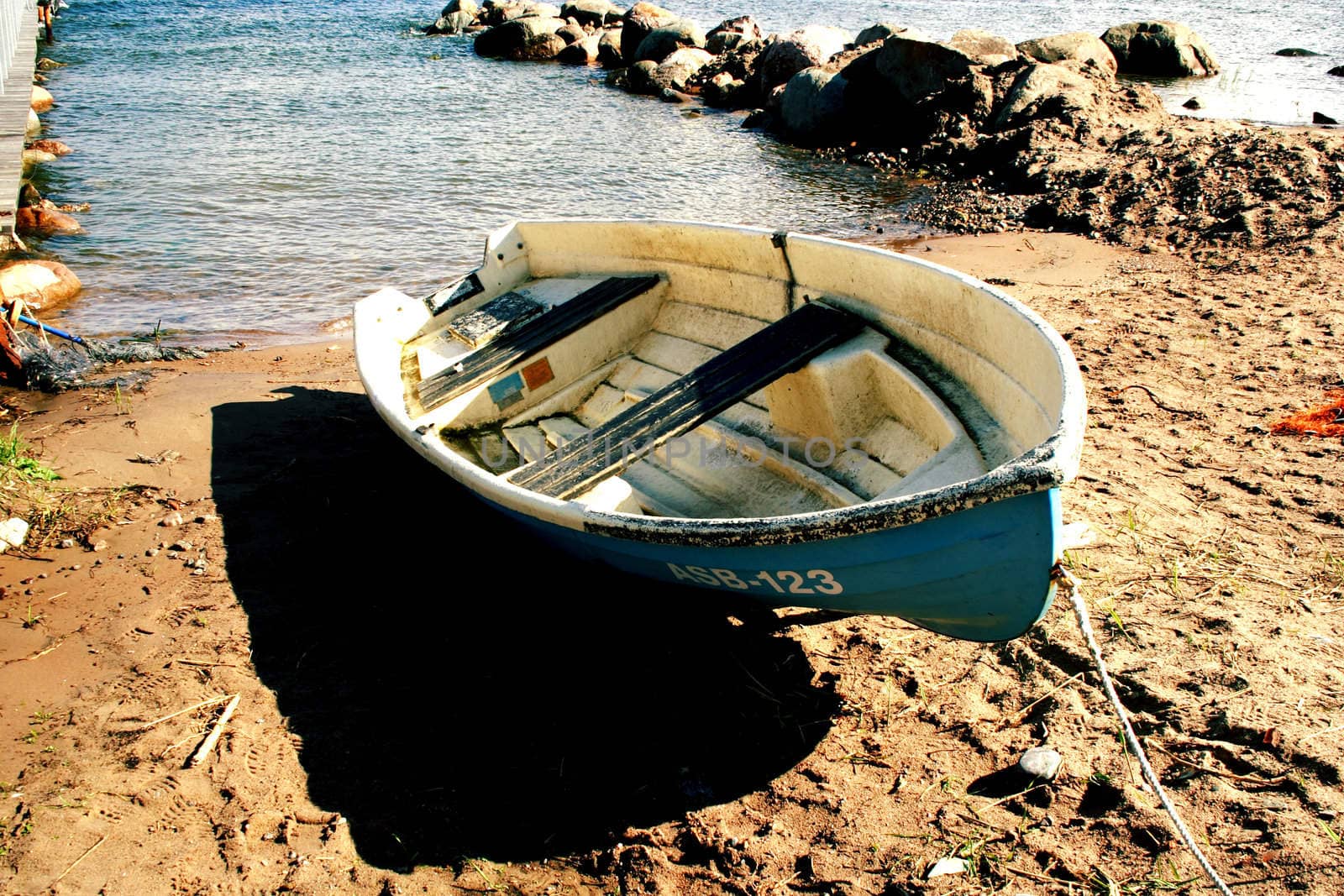 Boat laying on sandy beach at sunny day