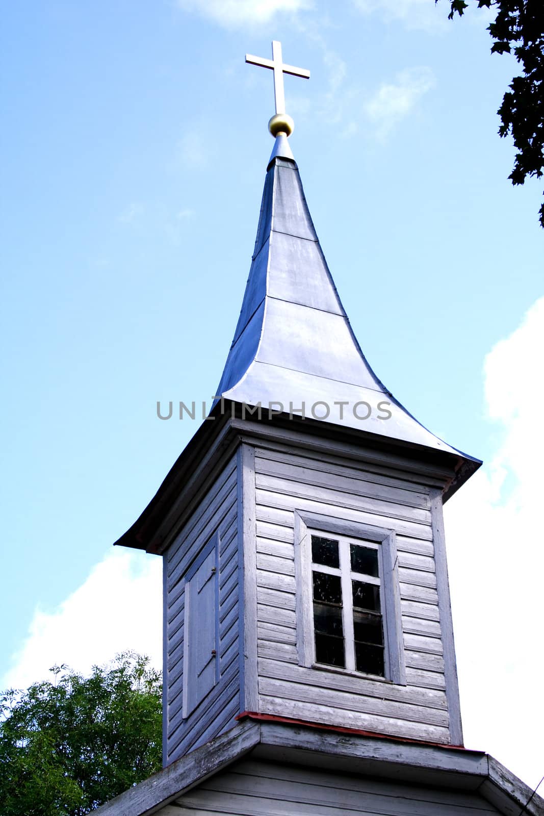 Wooden church tower with lighted cross on roof