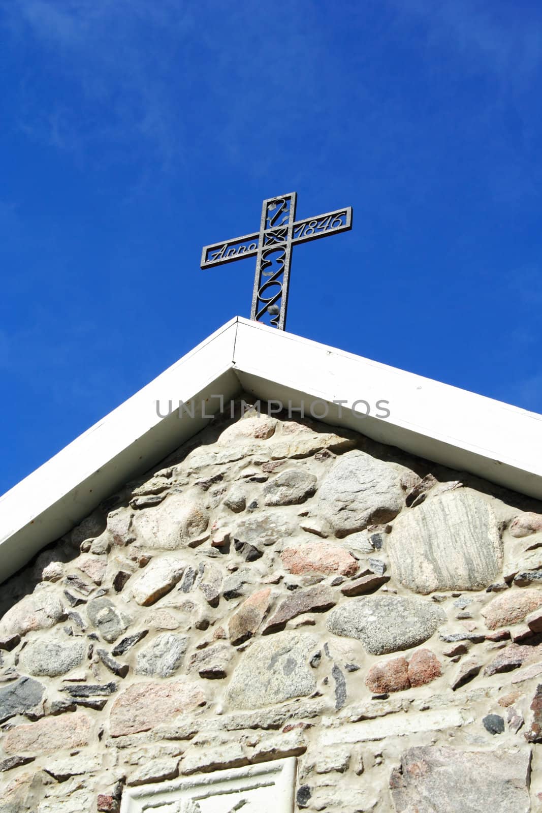 Cross from metal placed at old church roof