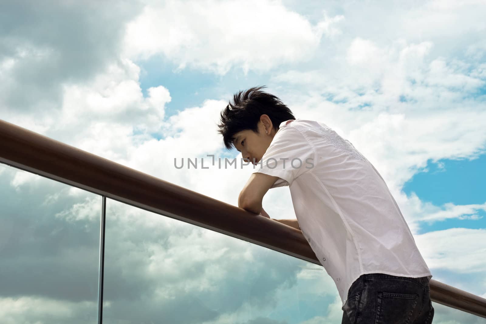 Sad boy hand on the handrail and sky background