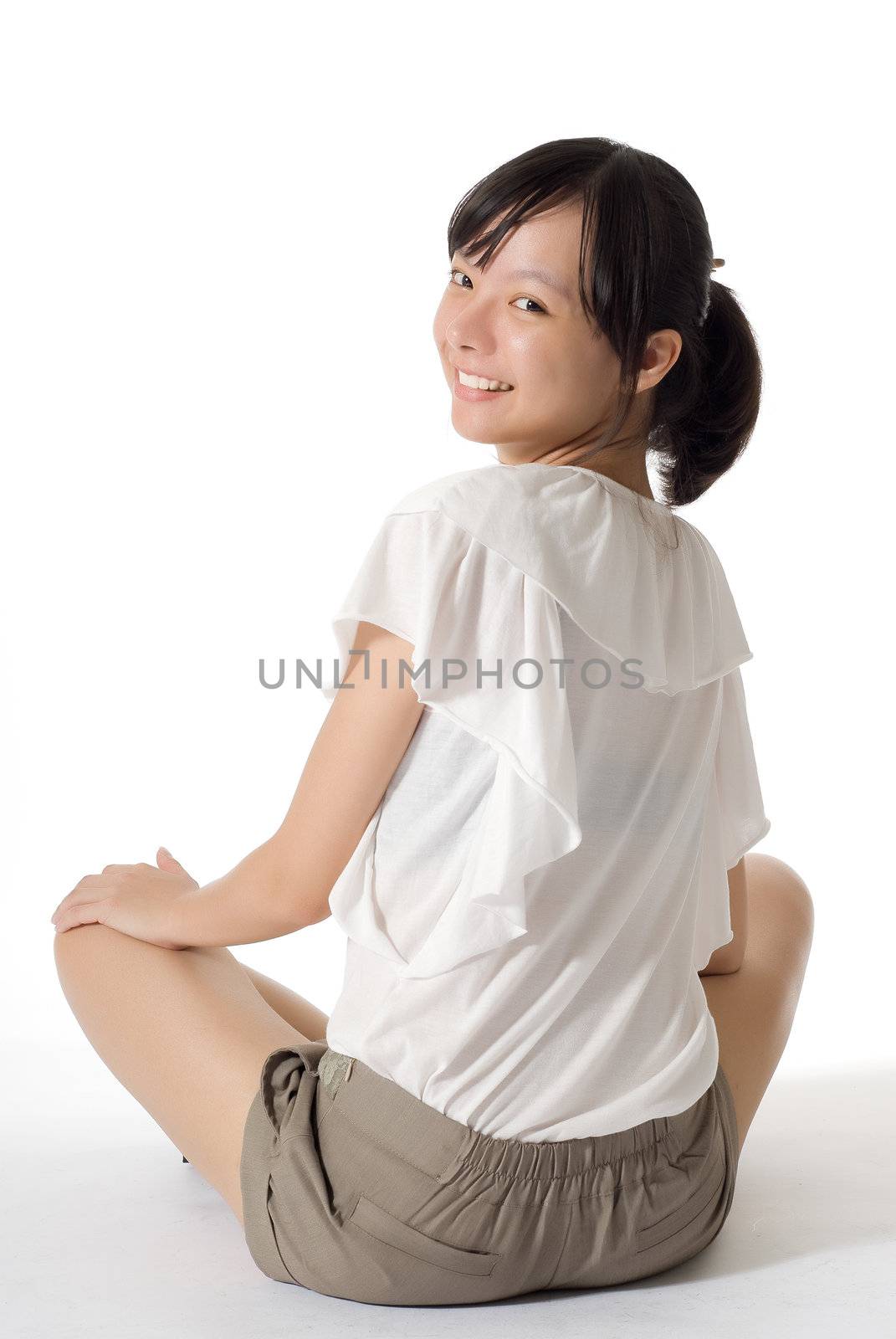 Happy smiling beauty sit on ground, full length portrait on white background.