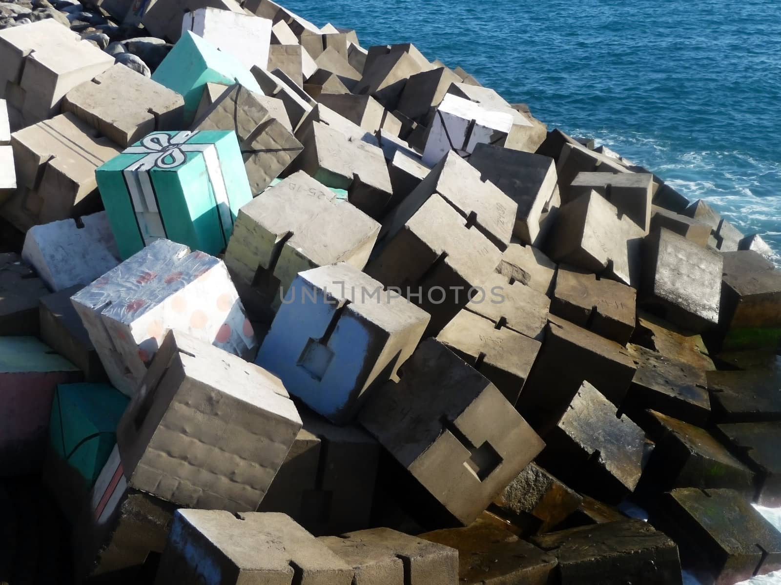 A view of the sea defenses in Gran Carnaria where someone has painted part of the defense to look like a present.