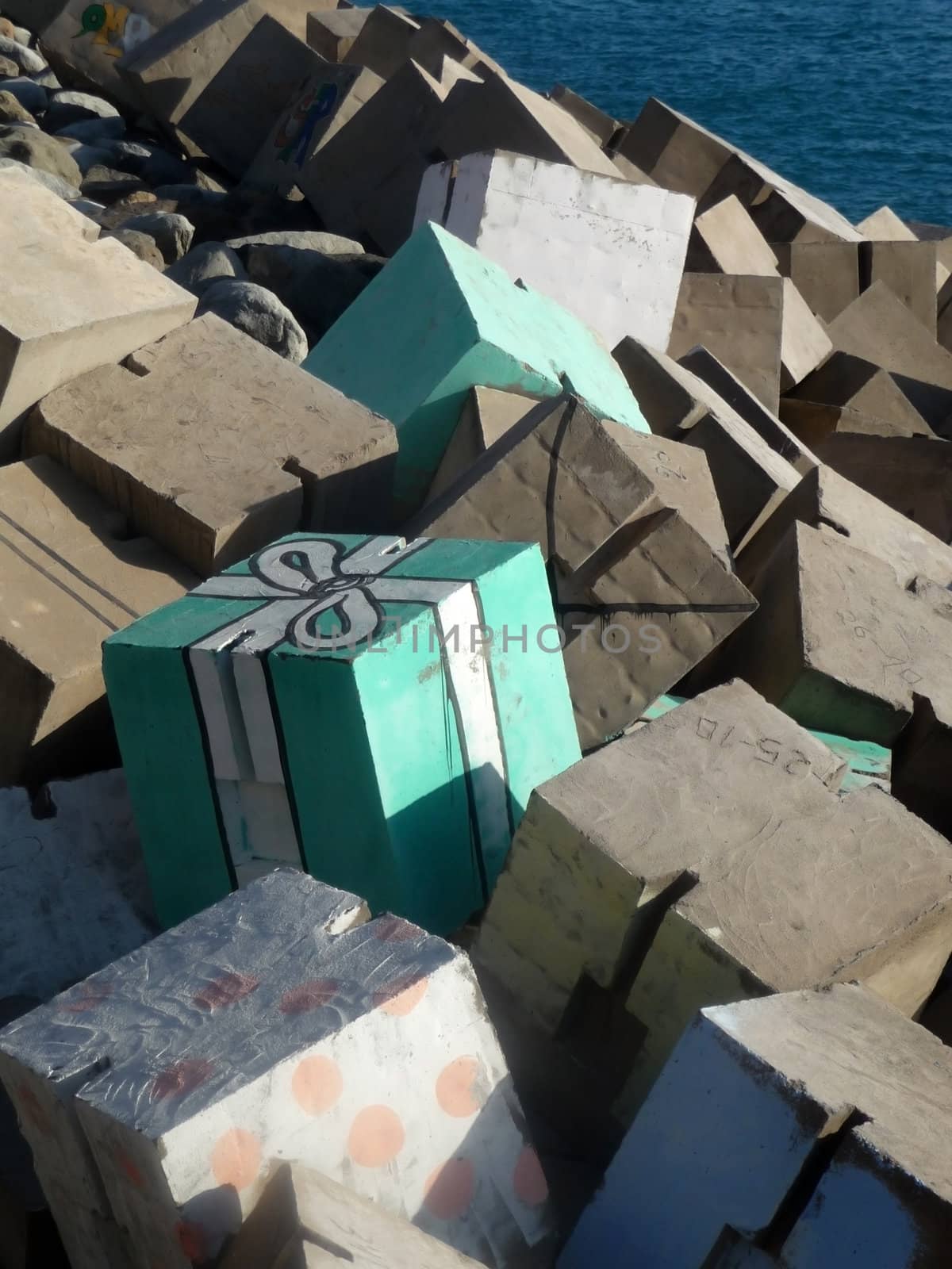 A view of the sea defenses in Gran Carnaria where someone has painted part of the defense to look like a present.