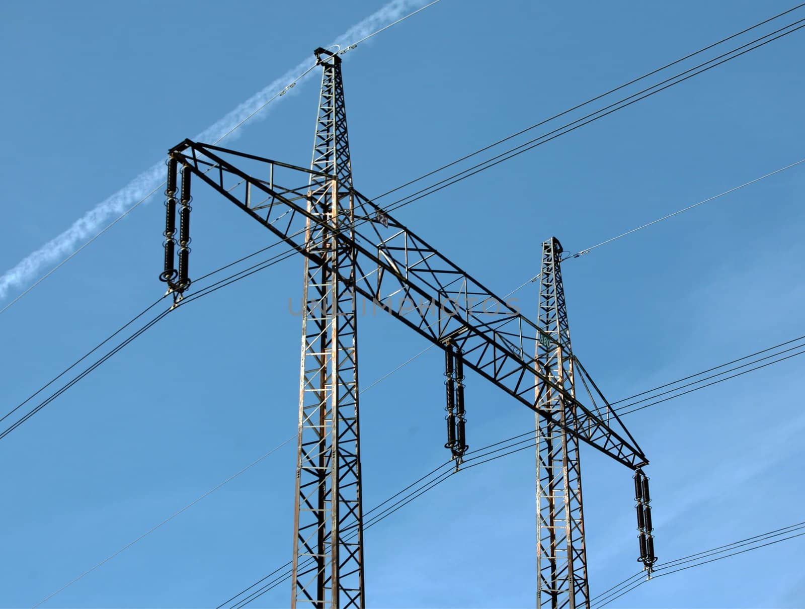 Electricity pylons and cables on the bright blue sky