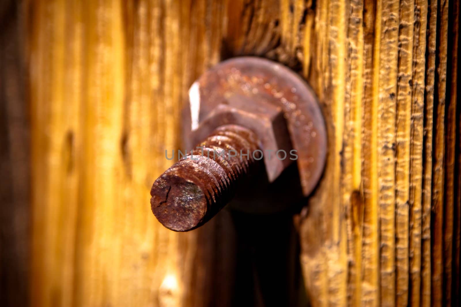 Grunge image of a rusty old bolt and nut in a wooden old post