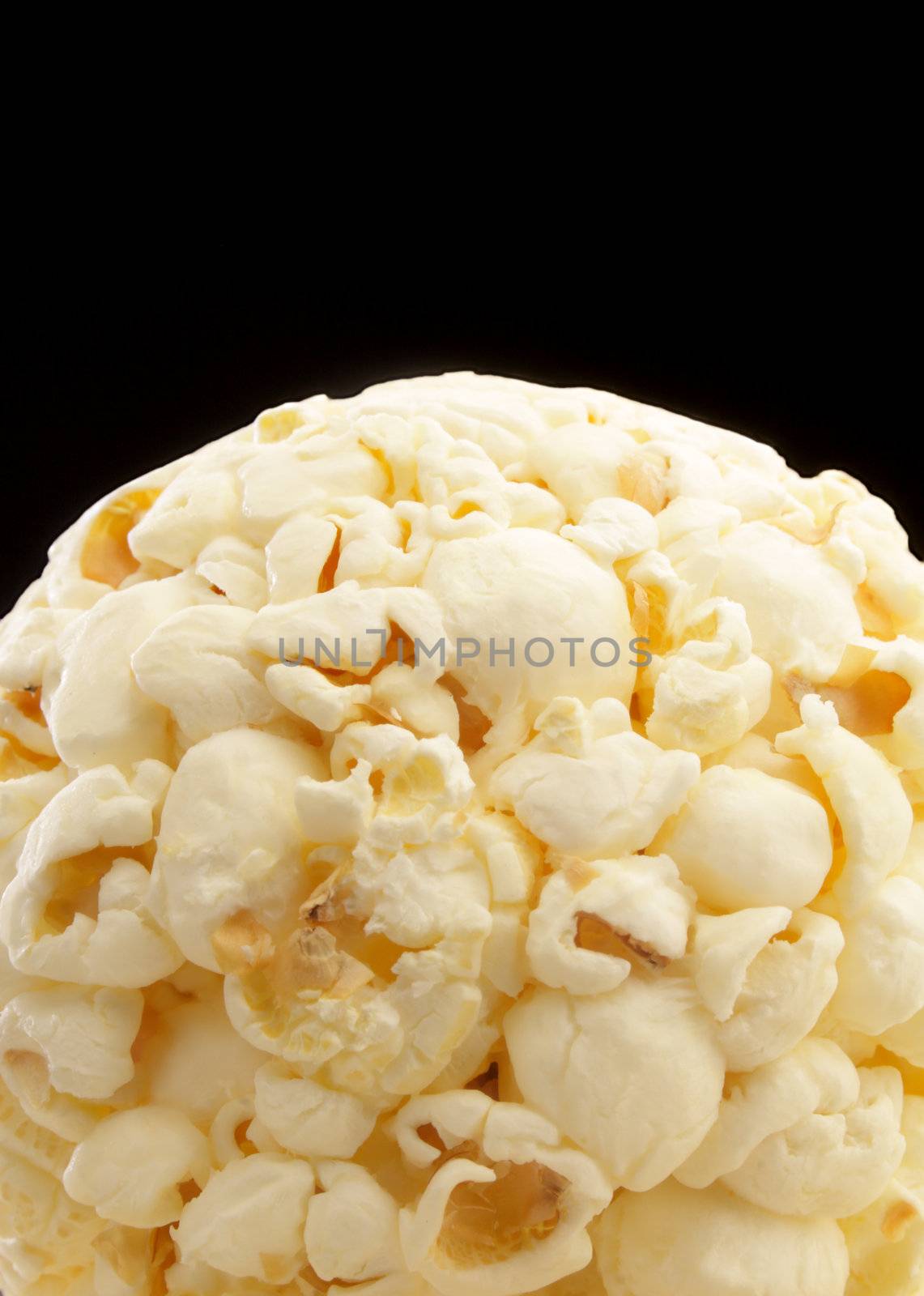 Closeup view of popcorn ball isolated on black with copy space.