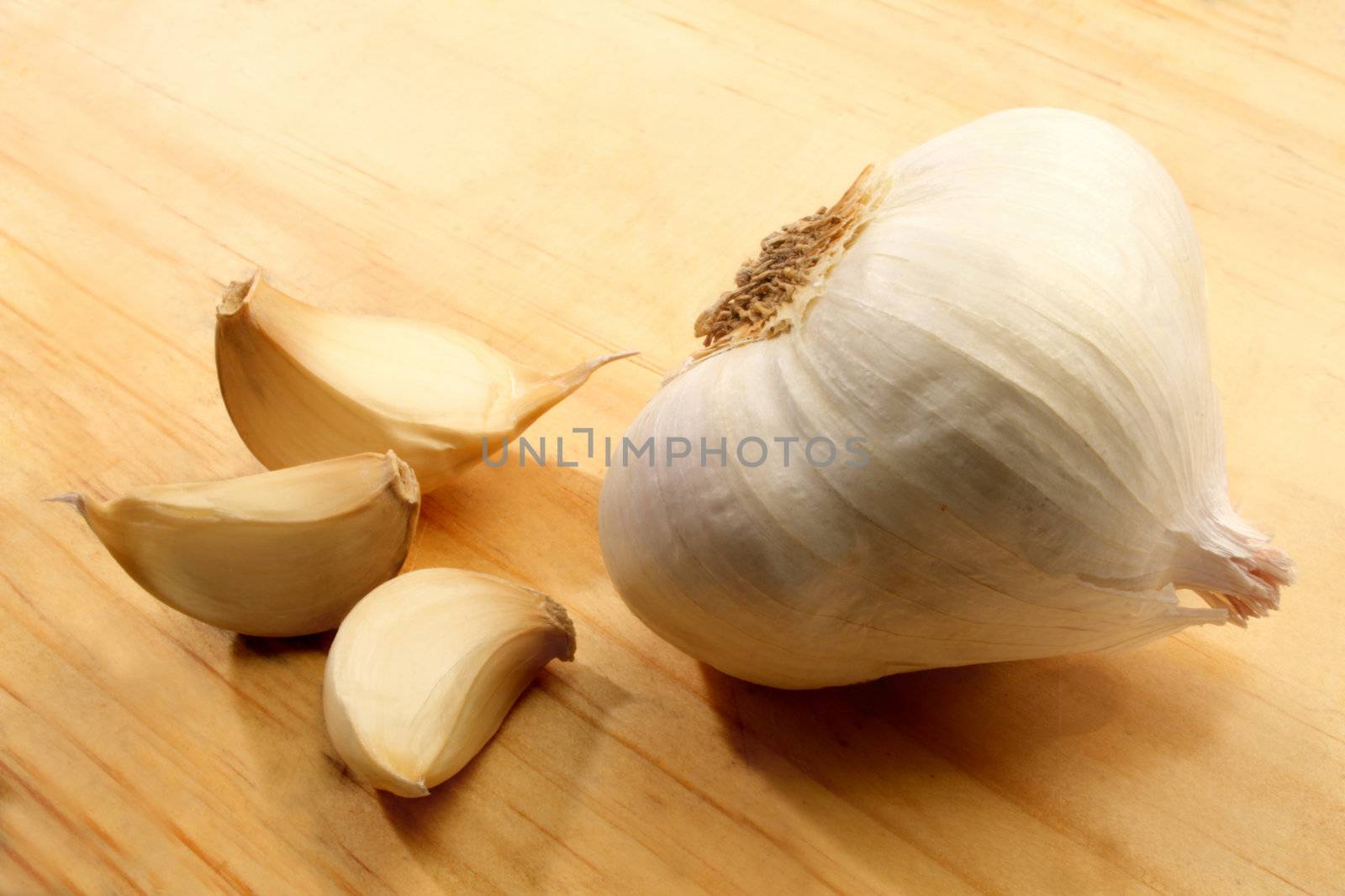 Garlic displayed on a wooden cutting board.