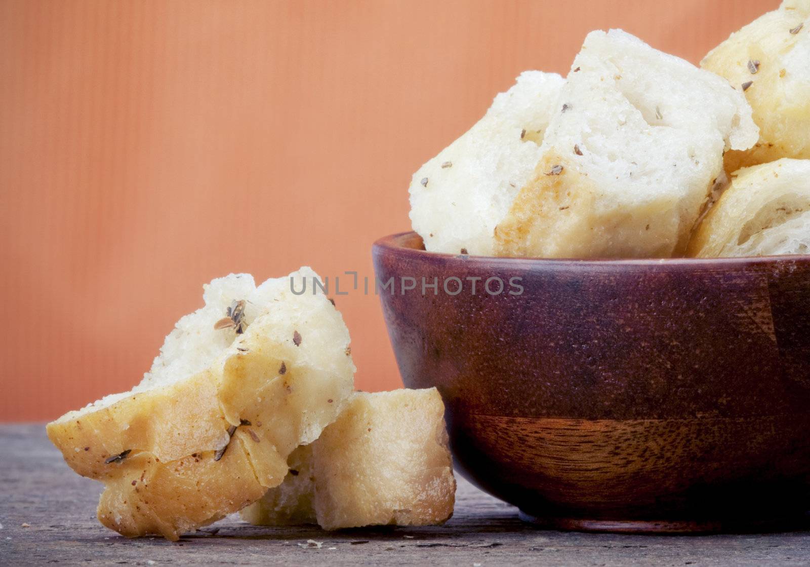 Croutons in a wooden bowl on a slate counter with copy space.