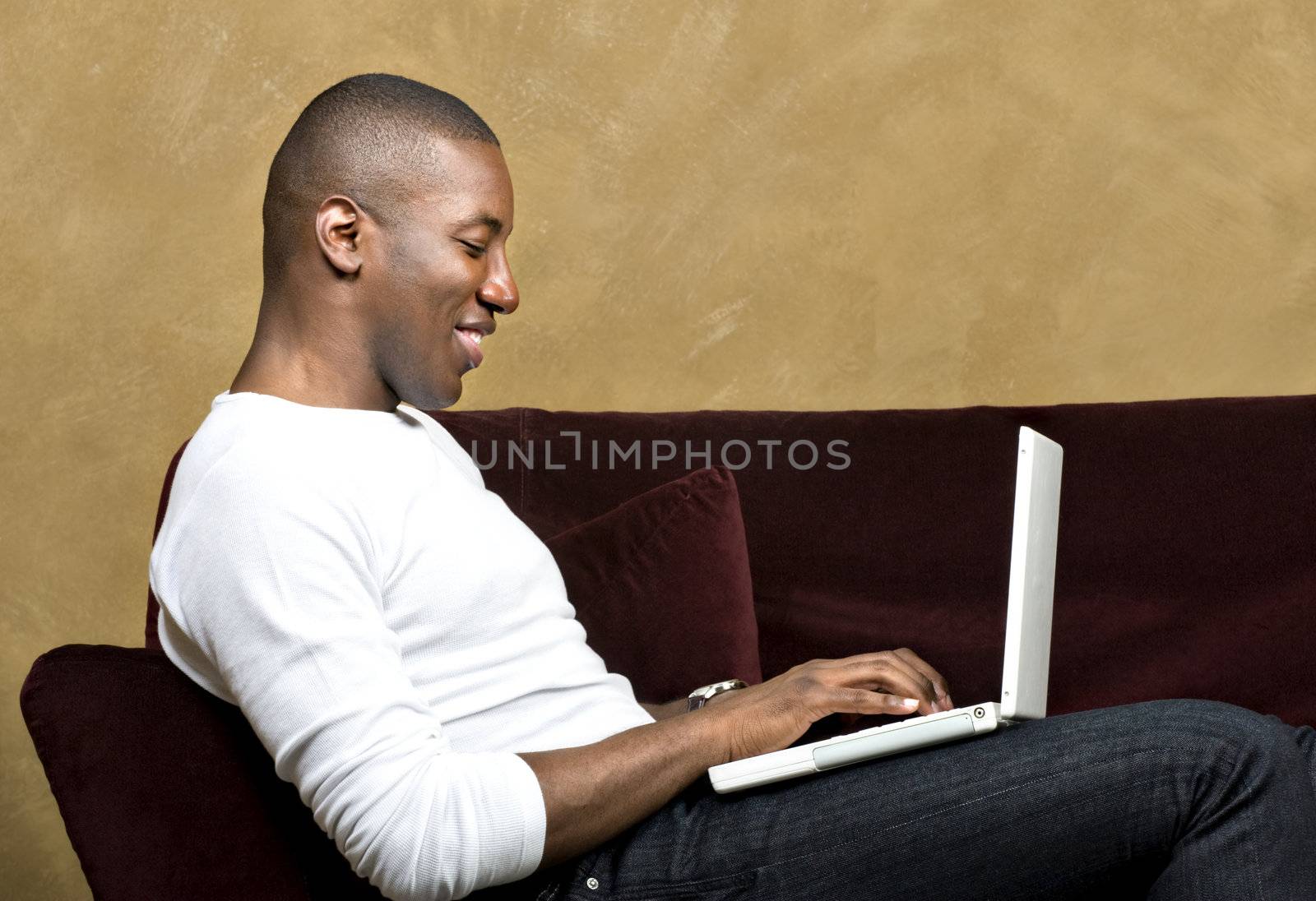 Handsome male model using laptop computer, with copy space.