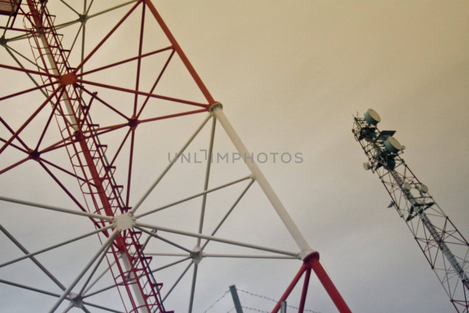 Two steel towers against cloudy dull sky on diagonal