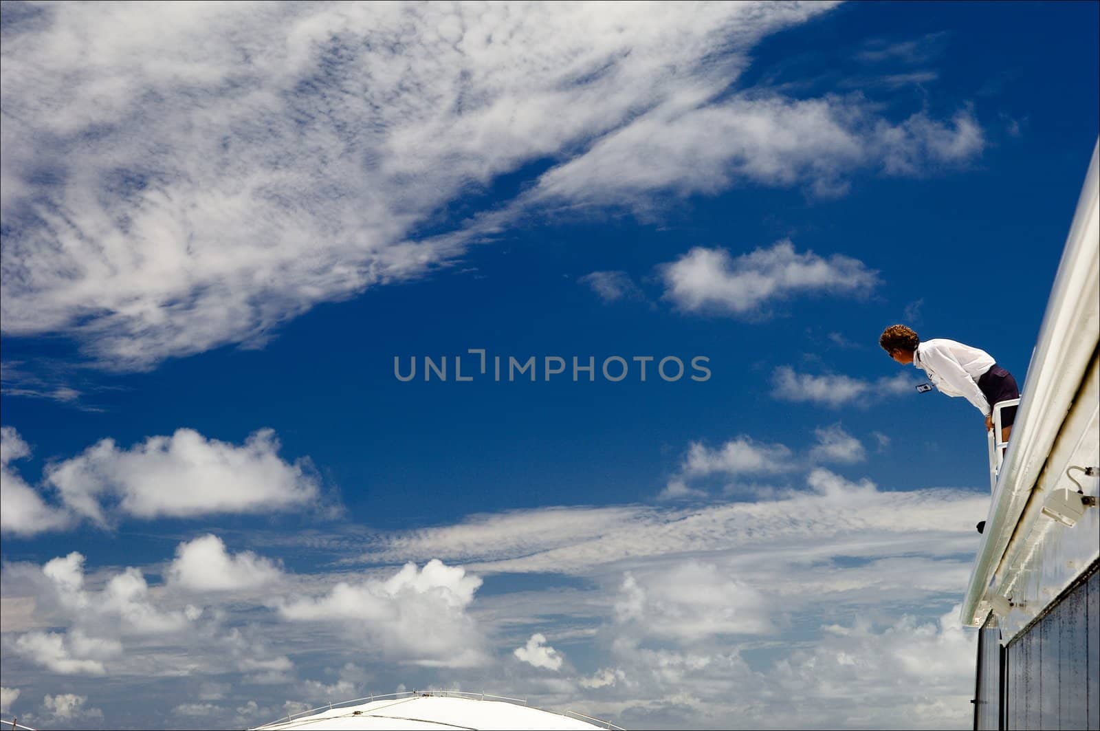 The heavenly steam-ship. The summer blue sky with white clouds and the steam-ship with the person who has overhung for a board.