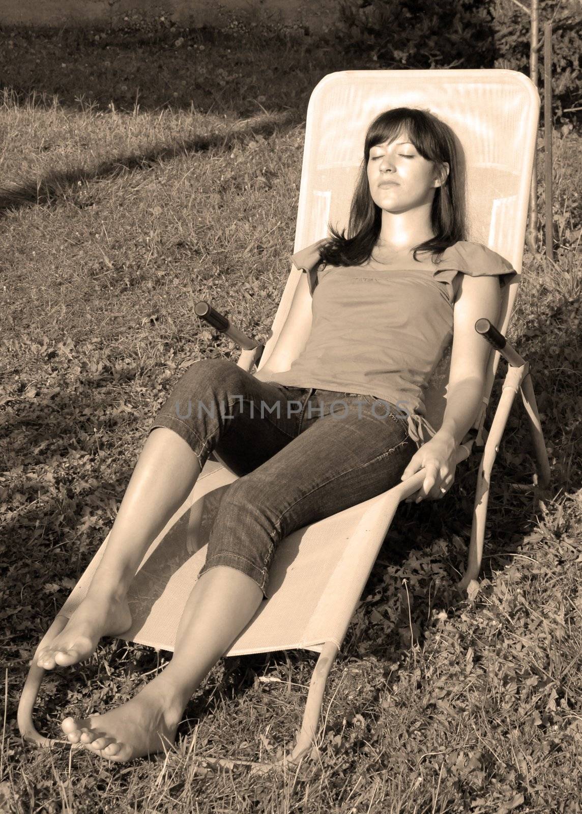 young woman relaxed in outdoor folding chair outdoor in black and white
