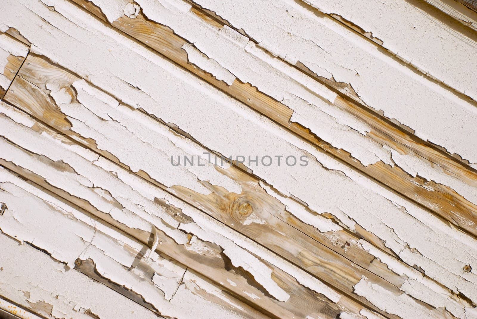 A very old wooden slat wall with serverly distressed and cracked paint