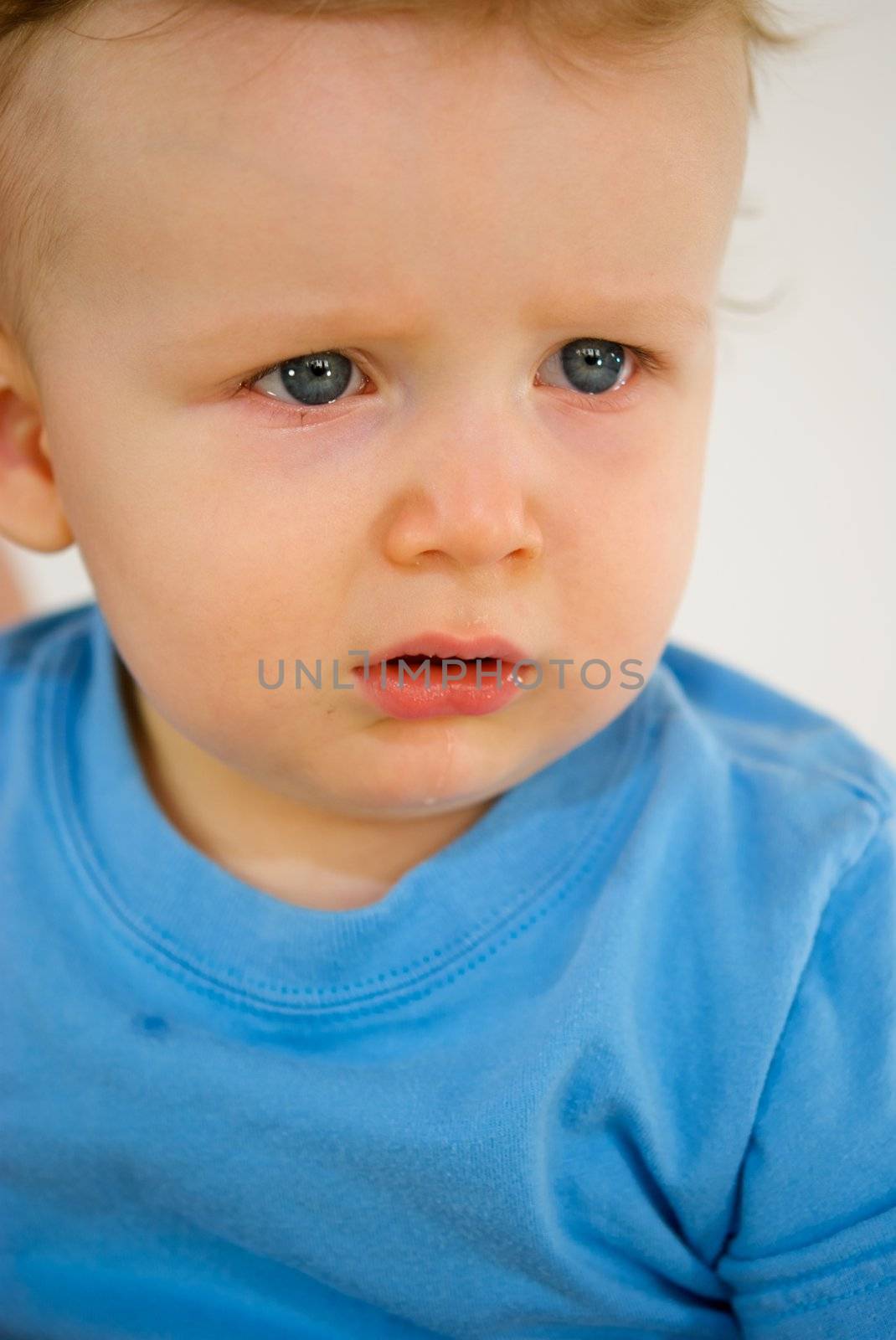 Little red headed boy with blue shirt crying