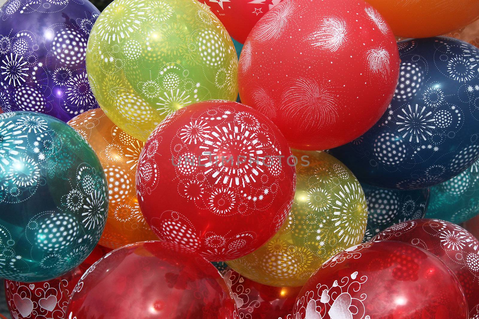 We see many colorful balloons with ornaments