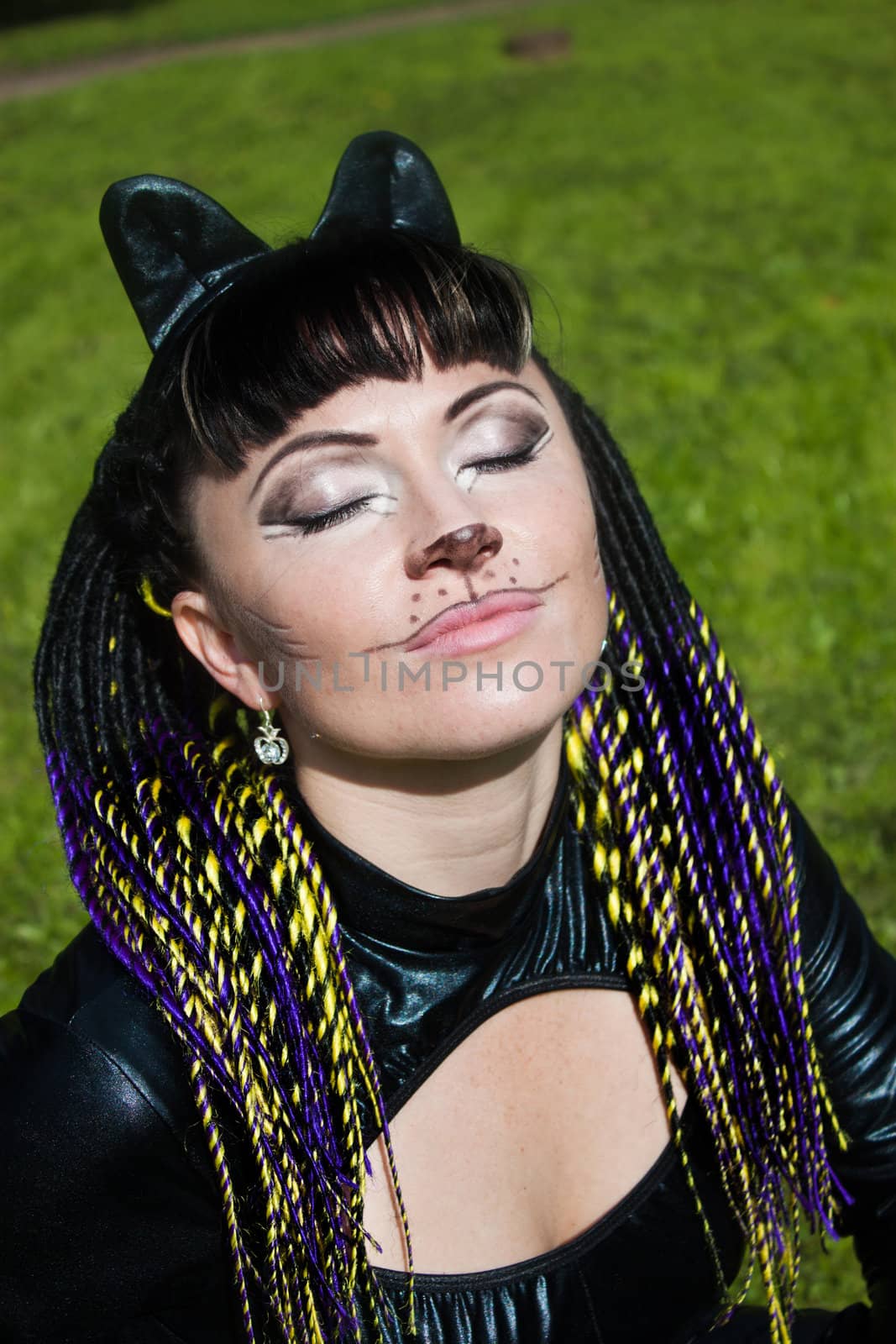 We see hot beautiful lady in latex cat costume. She's on the grass