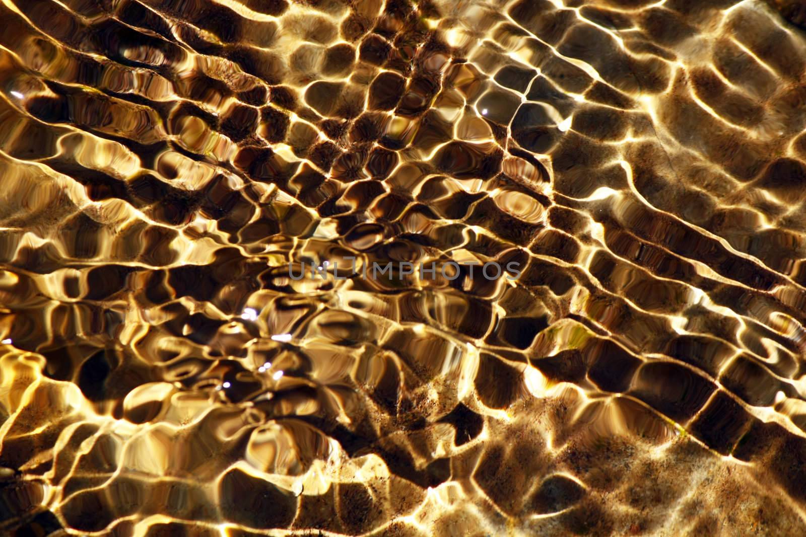 Close view of reflections of the water waves on the stream of a river.