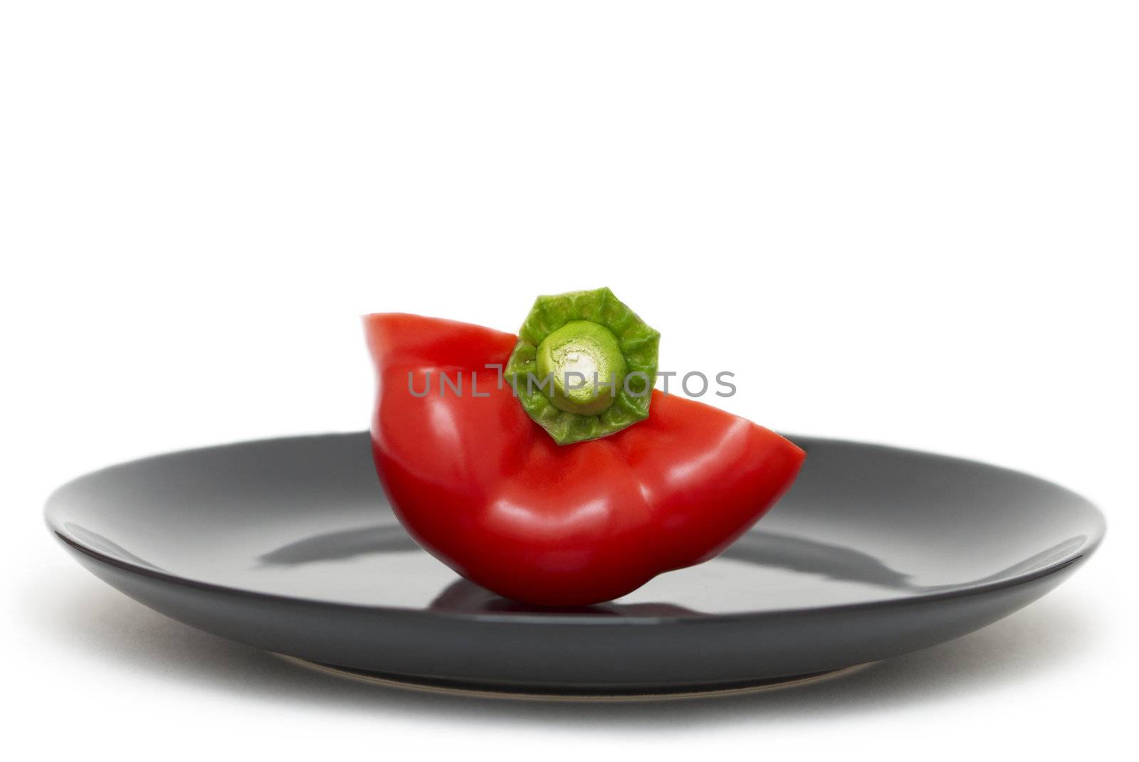 Half of red pepper on a black plate