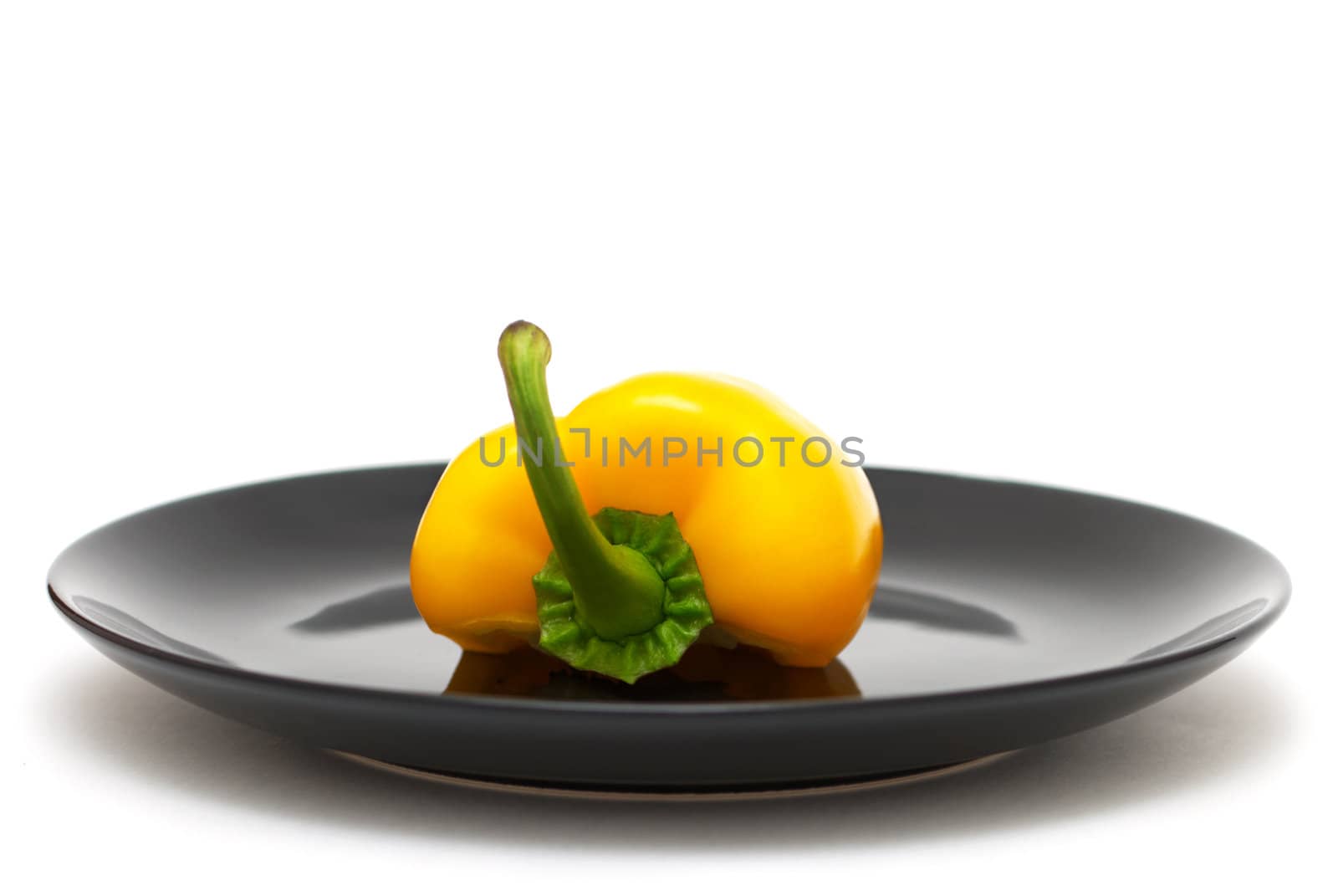 Half of yellow pepper on a black plate