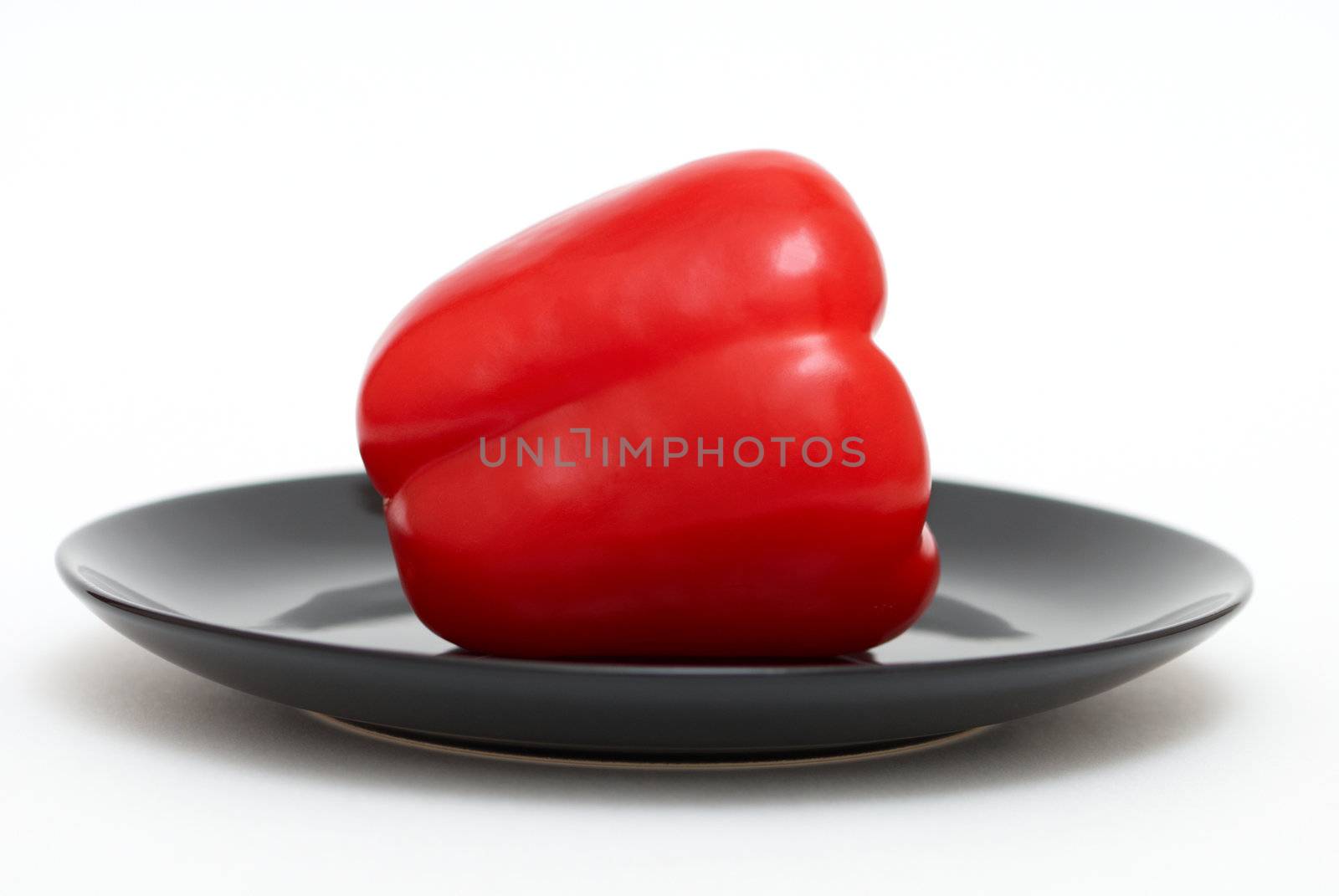 Red pepper on a black plate by Olinkau