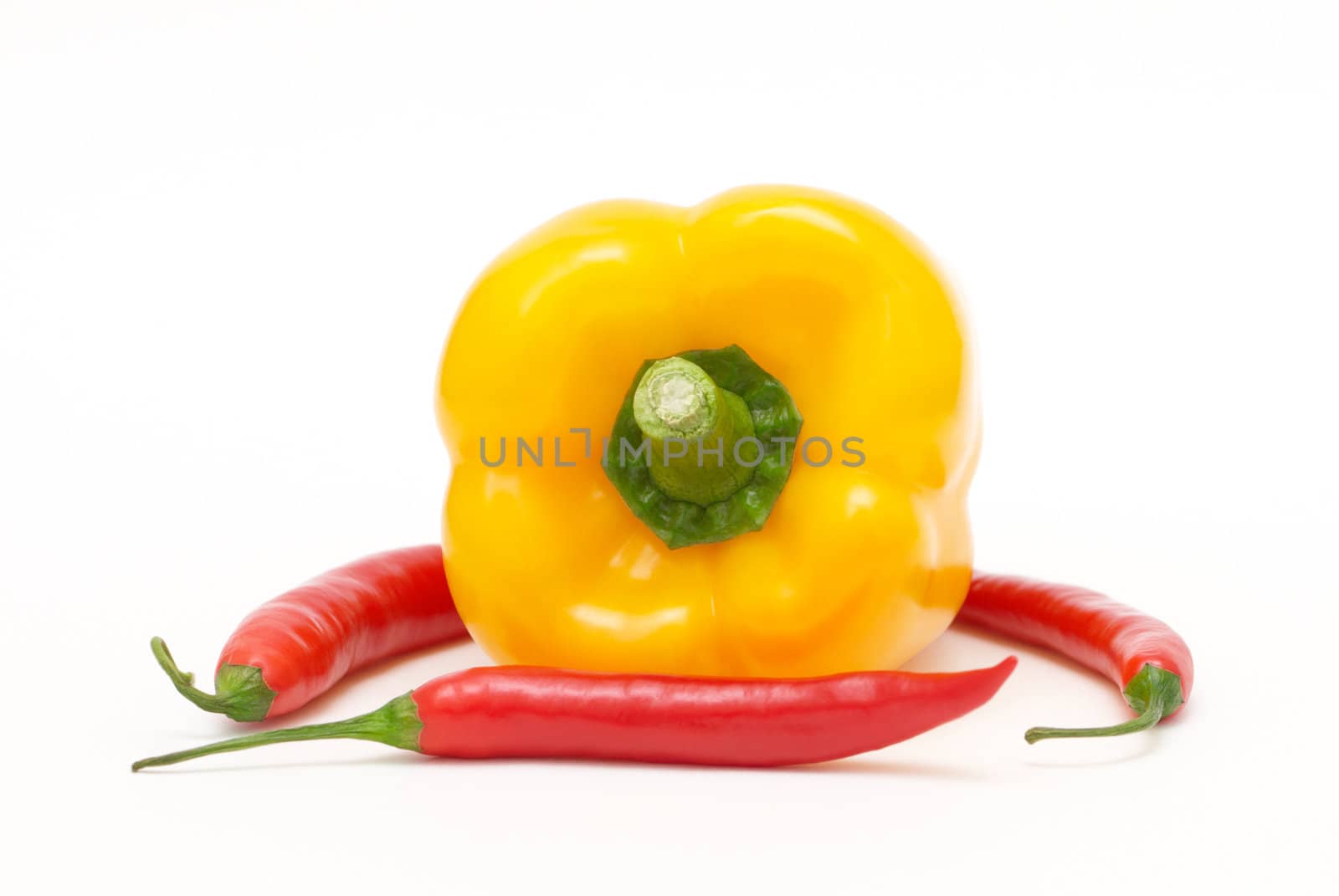 Yellow pepper with three red chili peppers on a white background 