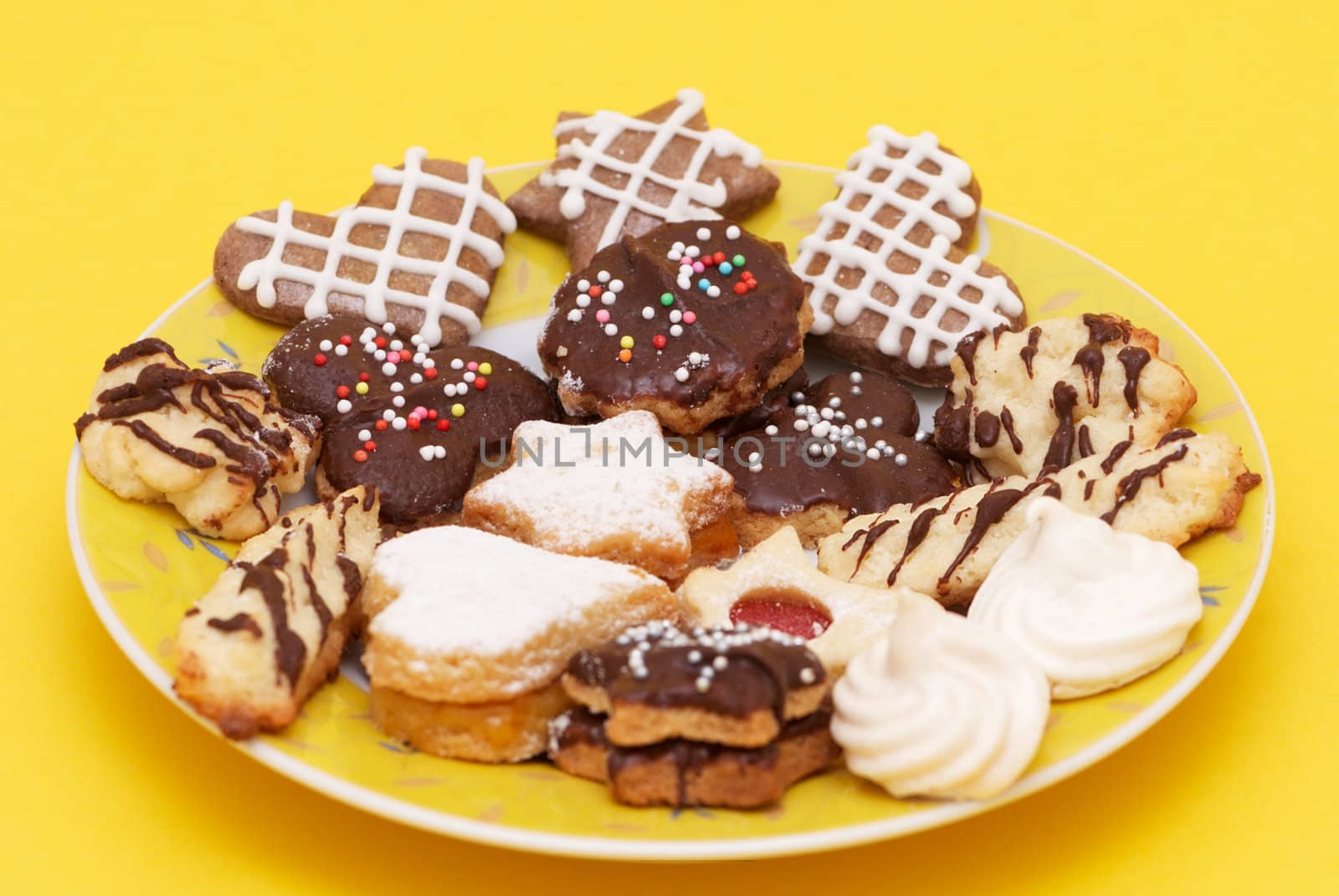 A group of Christmas cakes on yellow plate and yellow background