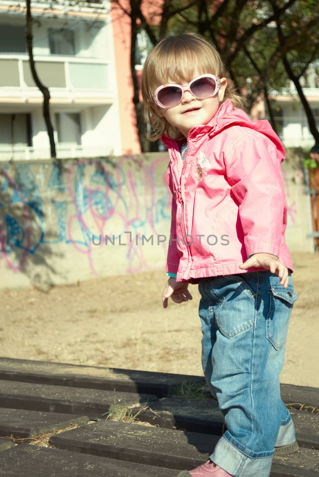 Portrait of a beautiful little girl outdoor in sunglasses.