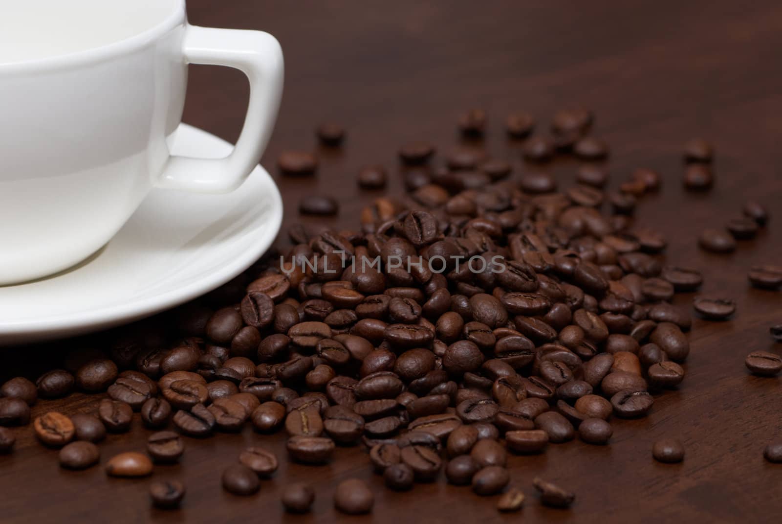 Coffee beans and cup on a brown wooden table