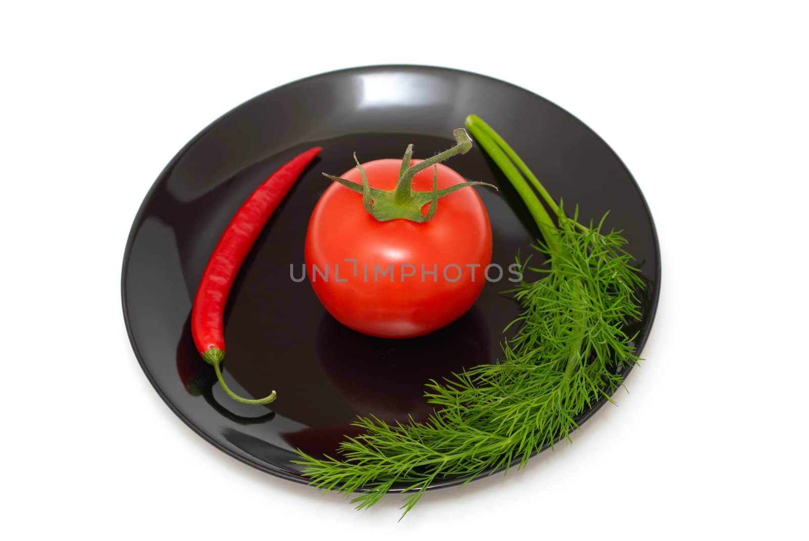 Tomato with a dill and chili pepper on a plate