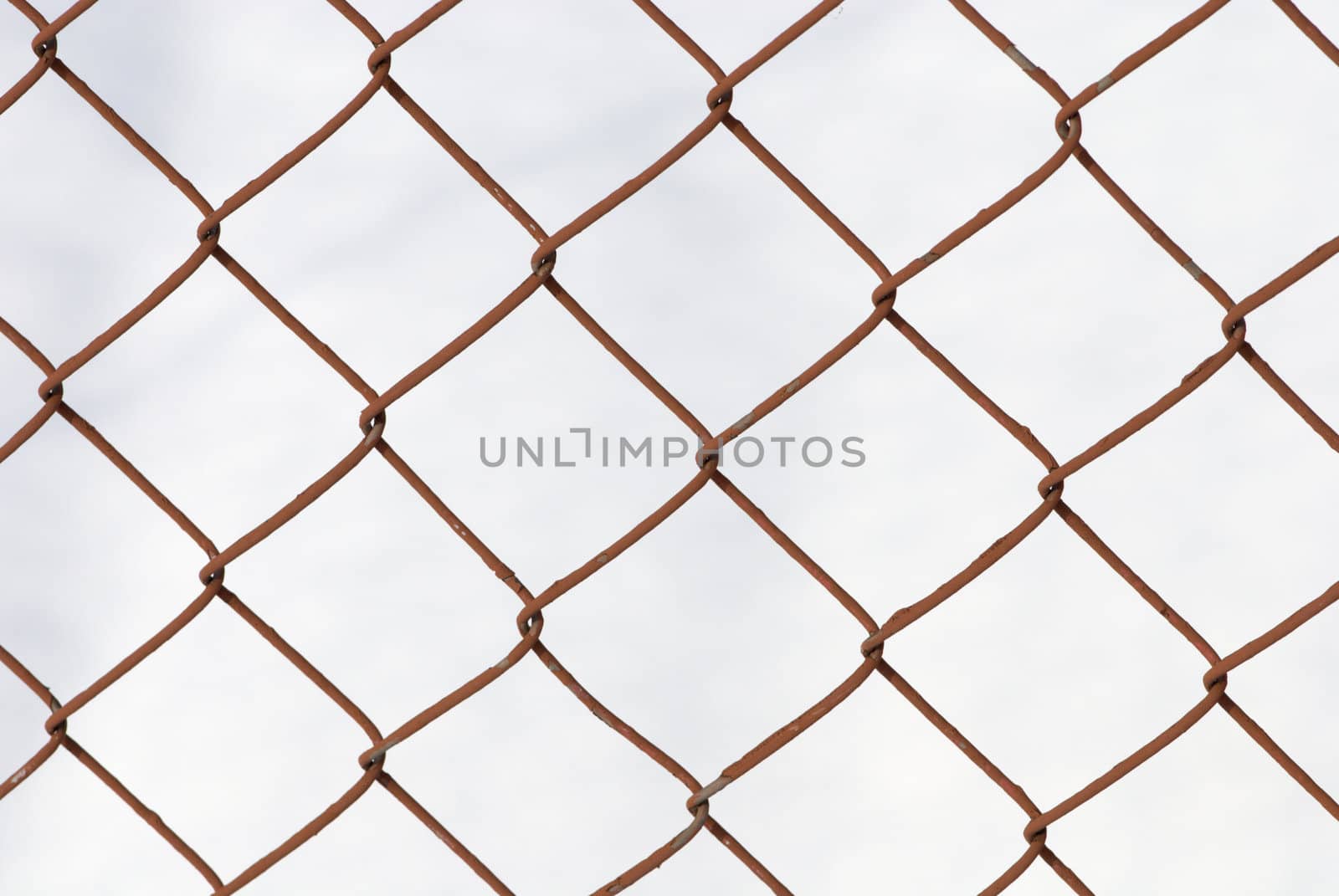 Knotted grid like chain-link fence against cloudy sky