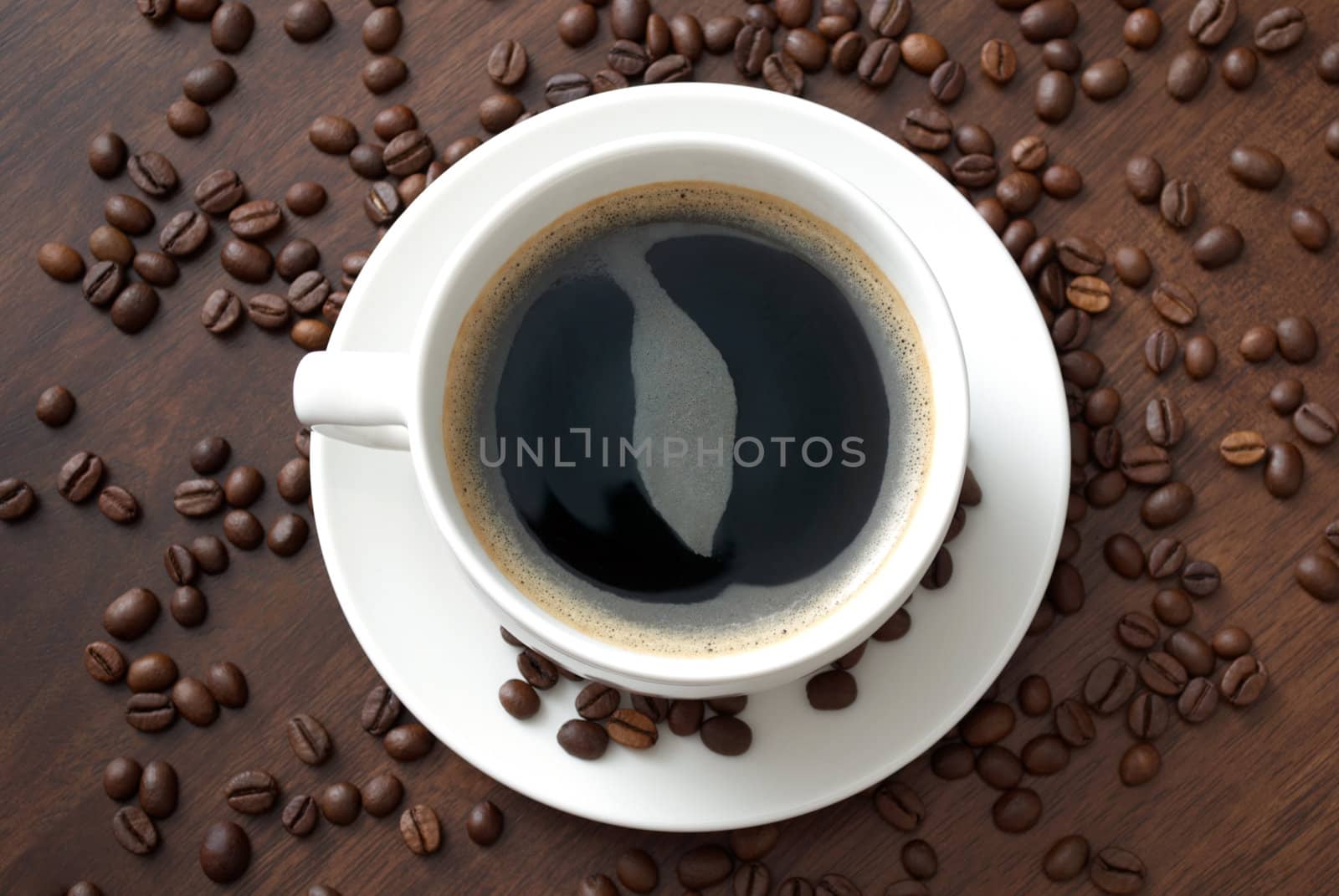 A cup of hot coffee on the table with coffee beans
