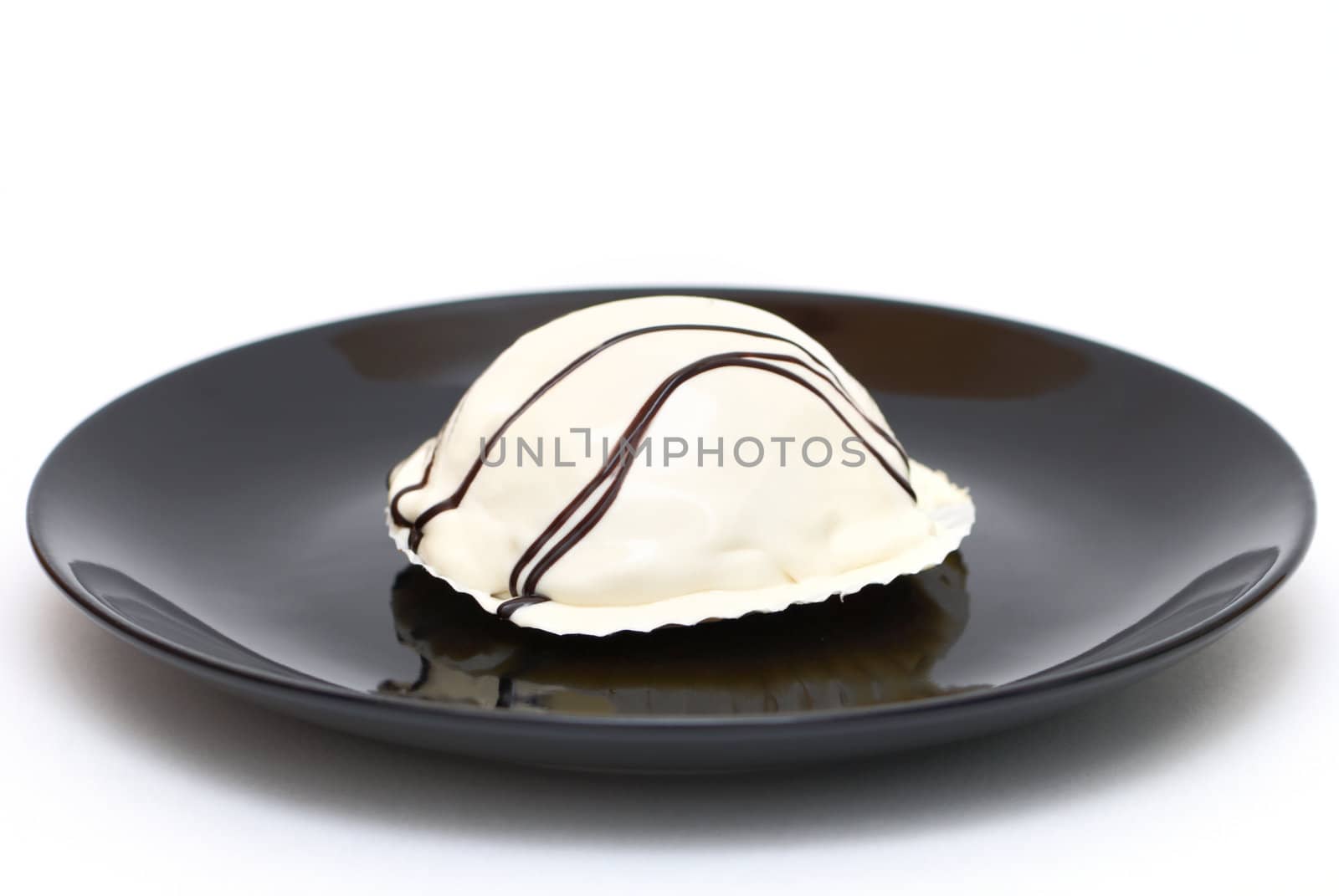White cake on a black plate isolated on white