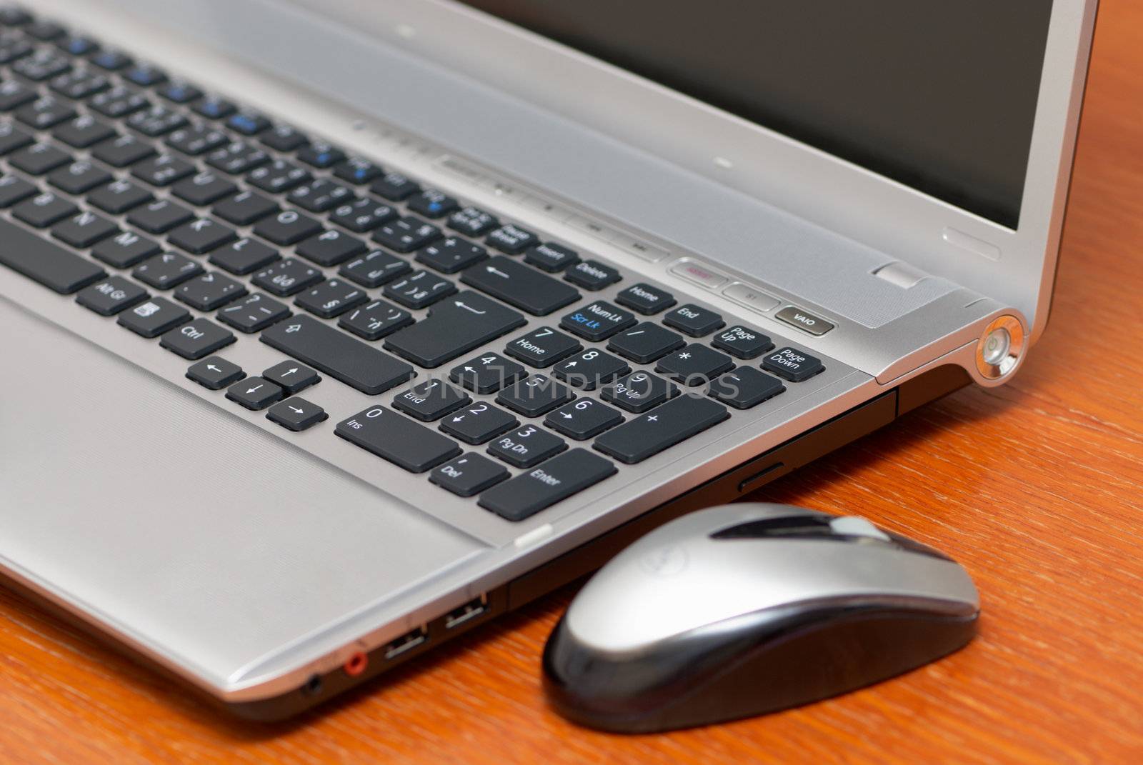 Silver laptop with mouse in the office