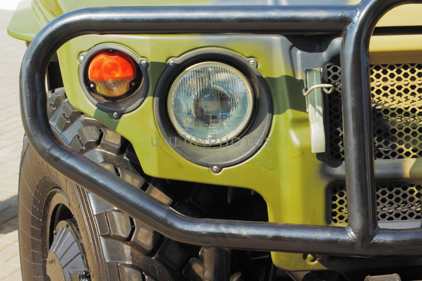 closeup green jeep headlight and turn wheel
