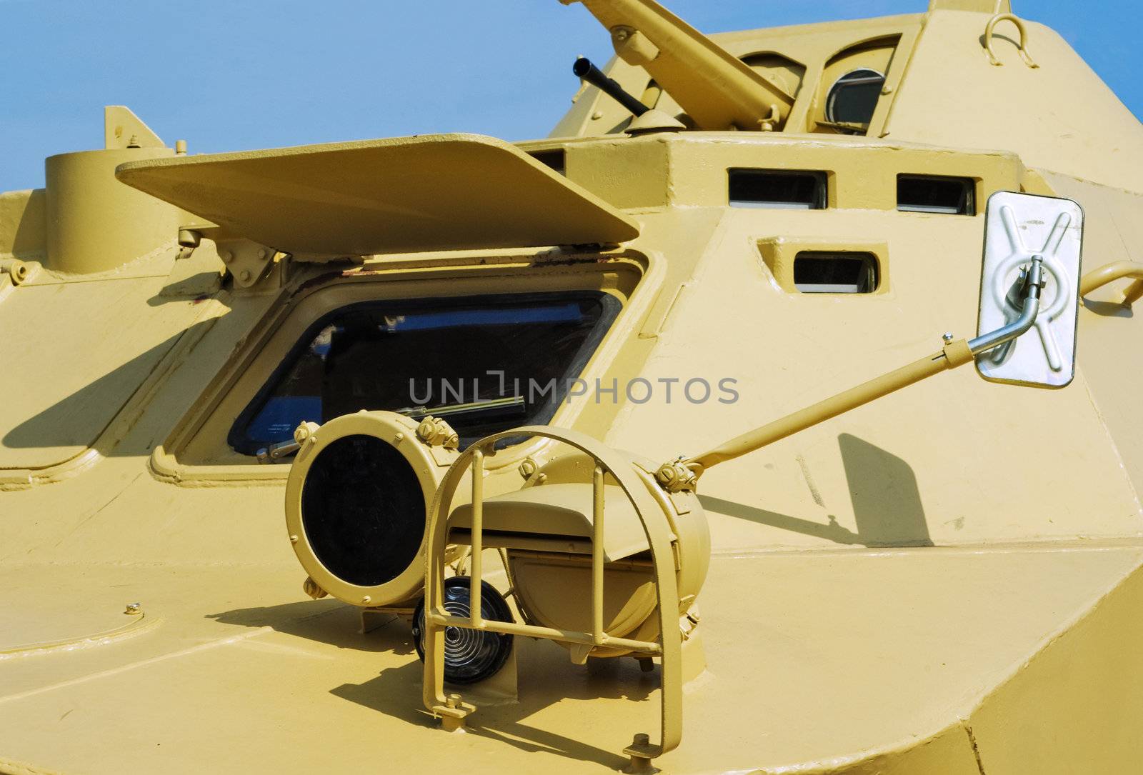 Headlights, a rear-view mirror and a driver window  of an armoured troop-carrier close up