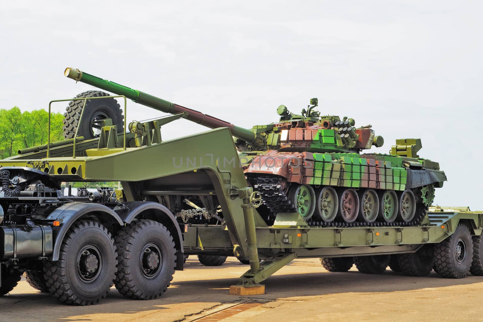 The tank on a wheel platform of the heavy lorry for transportation on asphalt road