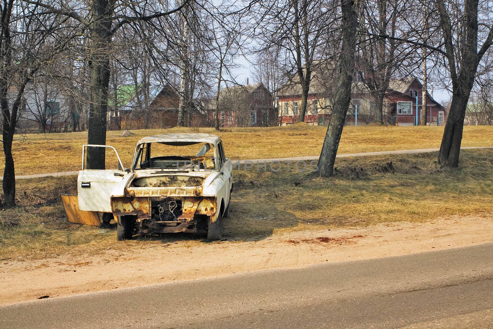 The old rusty thrown car on a highway roadside
