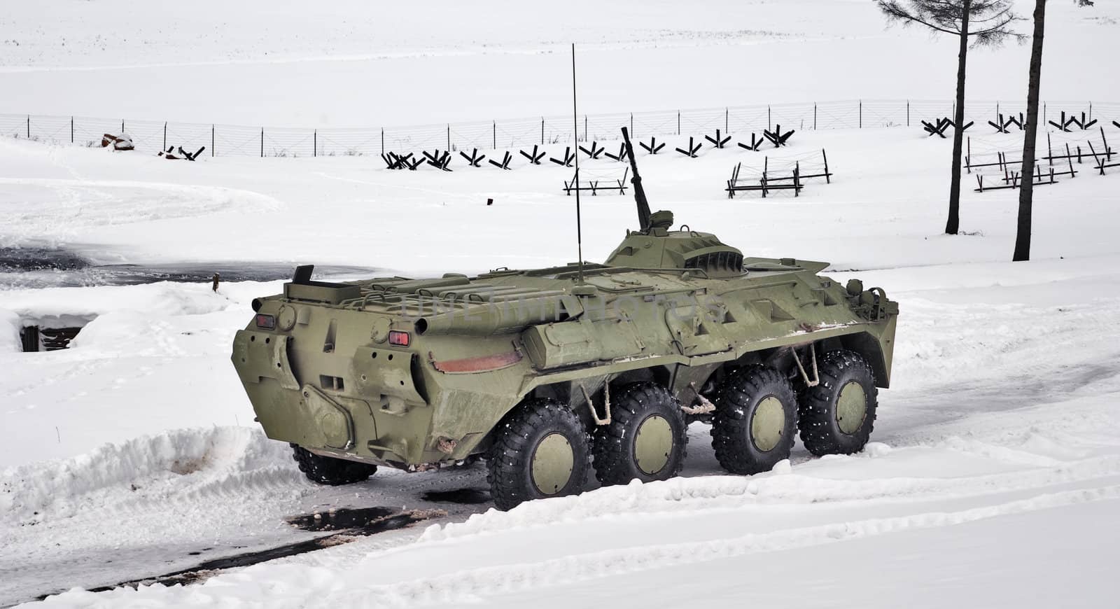 The green armoured troop-carrier goes on winter road