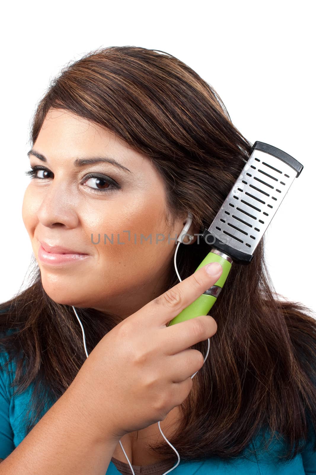 A young brunette woman listening to music while brushing her hair.