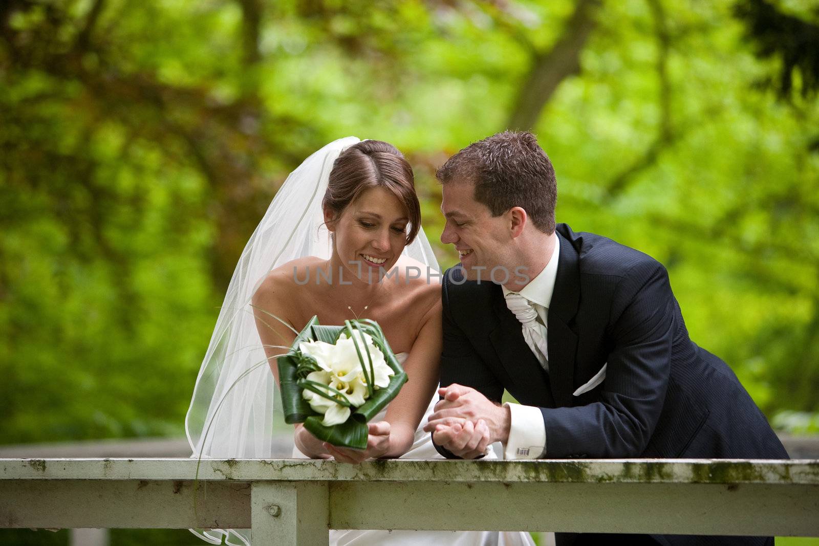 Beautiful bride and groom leaning over the railing for a quiet moment of happiness